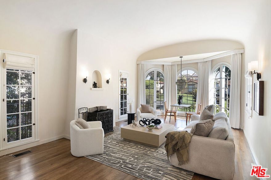 Originally built in 1928, and entirely remodeled and a second floor added to the house in 2005, 131 S Martel now has 6 beds and 4.5 baths over 3860 sq ft on a 7006 sq ft lot in a prime Miracle Mile location close to The Grove and Pan Pacific Park!  The front courtyard brings you to a glass door entrance and a center hall foyer with living room on one side and dining room on the other.  The living room has floor to ceiling arched windows at the front and a statement fireplace as the focal point of the room. The large formal dining room is surrounded by windows.  The remodeled wood kitchen has abundant cabinetry and countertop space, a center island, 3 sinks, 2 dishwashers, double wall oven + single gas oven, oversized fridge and freezer, walk-in pantry, and built in breakfast bar. A family room with built-ins drenched in sunshine is right off the kitchen and opens to the yard. There's a great office downstairs! There are 5 beds + large office and 4.5 baths, generous closet space, and remodeled bathrooms.   The primary bedroom suite has a large walk-in shower + built-in steam system + huge jetted tub with cable + Cat5 outlet. Hardwood floors, dual zone central HVAC, new solar energy + battery back-up system (that saves the current owners over 5k a yr in utility bills), 7-parameter security cameras + ADT security.  A grassy yard, doggy door from house to yard,  a garage for storage (that has power), and a tesla charger + high speed internet access.  The location is central and amazing, right near The Grove, Pan Pacific Park, world class shopping and restaurants.