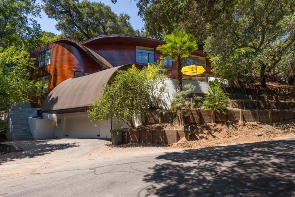 Architectural Gem in the Heart of Emerald Hills, this Fred Herring designed masterpiece blends architecture and nature in perfect harmony. Floor-to-ceiling seamless windows frame lush greenery and a serene creek that winds along the property. Mature trees provide natural privacy and a cool summer retreat, while abundant sunlight fills every room. Inside, soaring ceilings, expansive rooms, and dramatic architectural angles create a light, airy feel. Radiant heat throughout ensures year-round comfort, complementing the homes warm, inviting atmosphere. The residence features 3 spacious bedrooms, including a primary suite with two walk-in closets, a sitting area, and picturesque views of the surrounding landscape. An elevator conveniently connects the garage to the main living level perfect for heavy grocery runs or shopping hauls. The full basement offers exceptional versatility, having served as a man cave, photo development studio, movie theater, and rumpus room. Enjoy the tranquility of Lower Emerald Lake just moments away, with shopping, dining, and more within easy reach. This home is more than a residence its a work of art, designed for comfort, style, and a deep connection to nature.