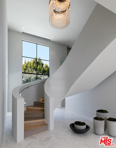 This extraordinary European estate in prime Beverly Hills showcases grand-scale living spaces, magnificent grounds and iconic views of L.A. Country Club and Century City in a serene and private setting. Behind gates on almost an acre of flat land, a grand, wraparound motor court studded with olive trees leads to sweeping, light-infused living spaces, including a living room with restaurant-caliber bar, dining room, theatre, auto gallery, phenomenal chef's kitchen and great room lined with French doors to impeccable grounds. A striking sculptural staircase leads to an open living area, office and six ensuite bedrooms, including the exceptional master with dual bathroom wings and showroom closets. A separate guest house and magnificent grounds, including a floating infinity pool and spa, water and fire features, cabana, outdoor kitchen, expansive lawns, and old-world gardens complete this unprecedented offering, just a heartbeat from the renowned shops and restaurants of Beverly Hills.