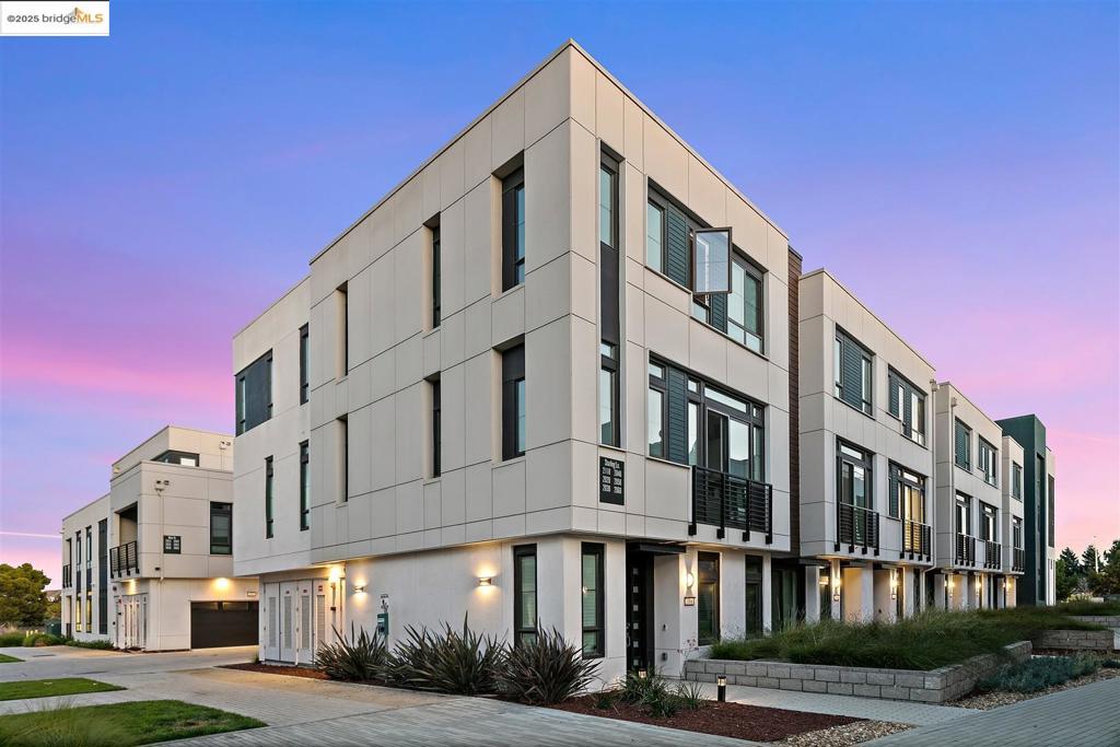 Located in Alameda's vibrant West End, this "nearly new" 2021 townhome in Leeward at Alameda Point HOA is one of only 64 townhomes in a development that won an architectural award in 2021 for Best Architectural Design. Filled with many builder upgrades, the home's multi-level contemporary floor plan features 3BR, 2.5 BA, an open LR/DR/kitchen great room & an attached 2-car garage.The sunny great room includes a 10-foot ceiling + a durable laminate floor in an attractive driftwood plank design.The kitchen has an abundance of cabinet storage, Calacatta quartz counters, high-end stainless steel appliances + a large center island for food prep and casual meals. The spacious primary bedroom includes an ensuite bathroom + a large walk-in closet w/custom organizers.Two additional bedrooms are both well sized, and provide plenty of natural light. The bathrooms feature attractive builder-upgrade finishes and materials. In addition to an award-winning architectural design, the HOA landscaping adds to the appeal w/drought-tolerant native plantings. Greenbelts, parks + a playground are steps from the front door! Situated just minutes from the SF Ferry and Alameda Point's many attractions, the location is convenient to Webster St shopping, the Alameda Farmers' Market and so much more! Turnkey
