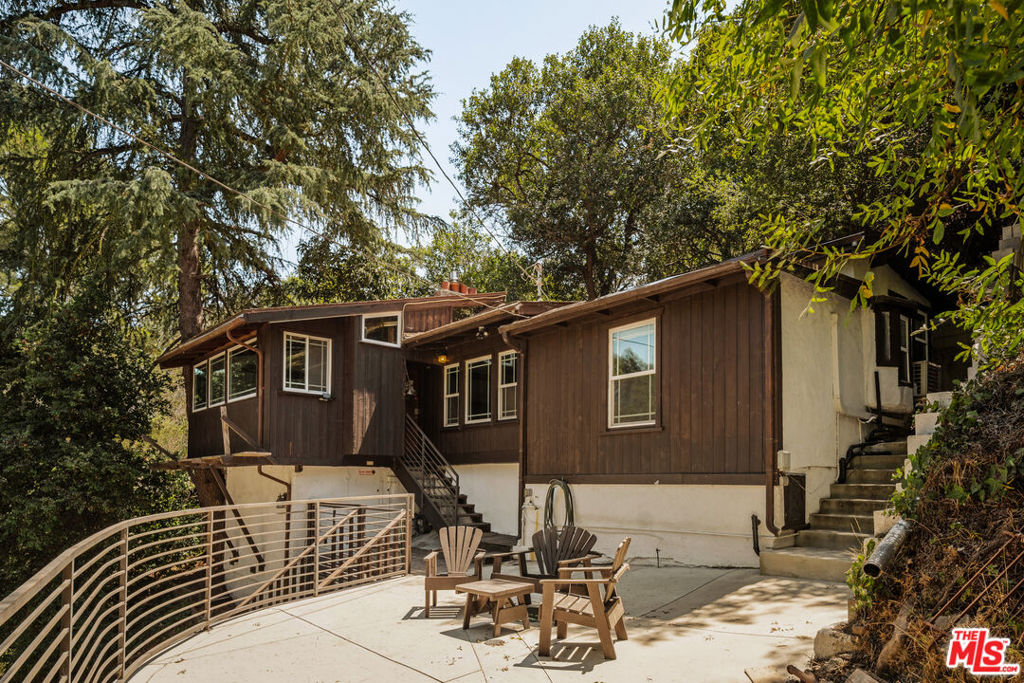 Tucked away on a private lane in Benedict Canyon, this property offers the rare feeling of escape, a true retreat that doesn't feel like LA living yet it's just minutes from Beverly Hills. Spread across three APNs and over half an acre of lush canyon landscape, this preserved artist's bungalow exudes vintage charm. Inside, original oak details, vaulted ceilings, solar powered skylights, and a stone fireplace create a warm, timeless atmosphere. A large refinished deck opens to peaceful canyon views, ideal for quiet mornings or intimate gatherings. With Hollywood history (once home to heiress Laura Harding and host to a performance by The Mamas & the Papas), the home offers endless potential to expand, restore, or reimagine, all while honoring its historic soul.