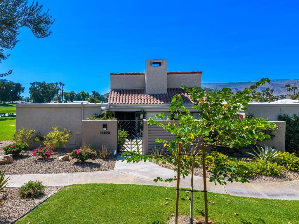 Rare end unit with spectacular south-facing views of two lakes, the Tournament Course, and the mountains! Beautifully renovated, this spacious 3-bedroom, 3-bathroom home offers 3,066 square feet of stylish living space.The living area strikes the perfect balance of modern sophistication and relaxed comfort. Soaring vaulted ceilings with whitewashed beams and expansive windows fill the space with natural light, framing sweeping views of the lakes, mountains, and lush greenery. Anchored by a sleek contemporary fireplace, the open layout is ideal for both entertaining and everyday living. Sliding glass doors extend the living space outdoors, blending indoor comfort with year-round enjoyment of the stunning surroundings.The kitchen is both functional and elegant, designed with rich dark cabinetry, light quartz countertops, and a large center island with bar seating for 6. Perfect for casual dining or entertaining, it features newer stainless steel appliances, including a double oven and French-door refrigerator. Ample storage, expansive counter space, and glass-front upper cabinets add both convenience and style. The open-concept design seamlessly connects the kitchen to the dining and living areas, while large windows and sliding doors highlight the incredible views.The primary bathroom is a private sanctuary, featuring a spacious walk-in shower with sleek glass doors, white tile, and matte black fixtures. Built-in shelving and a bench add comfort, while the expansive vanity with rich wood cabinetry and quartz countertops offers both beauty and functionality. Mirrored closet doors enhance the natural light and provide generous storage.The guest bathroom is equally refined, with a quartz countertop, dark cabinetry, and matte black fixtures. A frameless glass shower with sliding doors creates an open, airy feel, while marble-look flooring, neutral tones, and contemporary lighting add a touch of luxury.Located not far from the pool area with breathtaking views of the renowned Dinah Shore Tournament Course, this Mission Hills property is truly one-of-a-kind. HOA fees include front yard maintenance, gated security, cable TV, internet, community pool access, and more. The land lease has been extended to 2121.This exceptional home combines modern updates, timeless design, and unmatched views--an opportunity not to be missed.