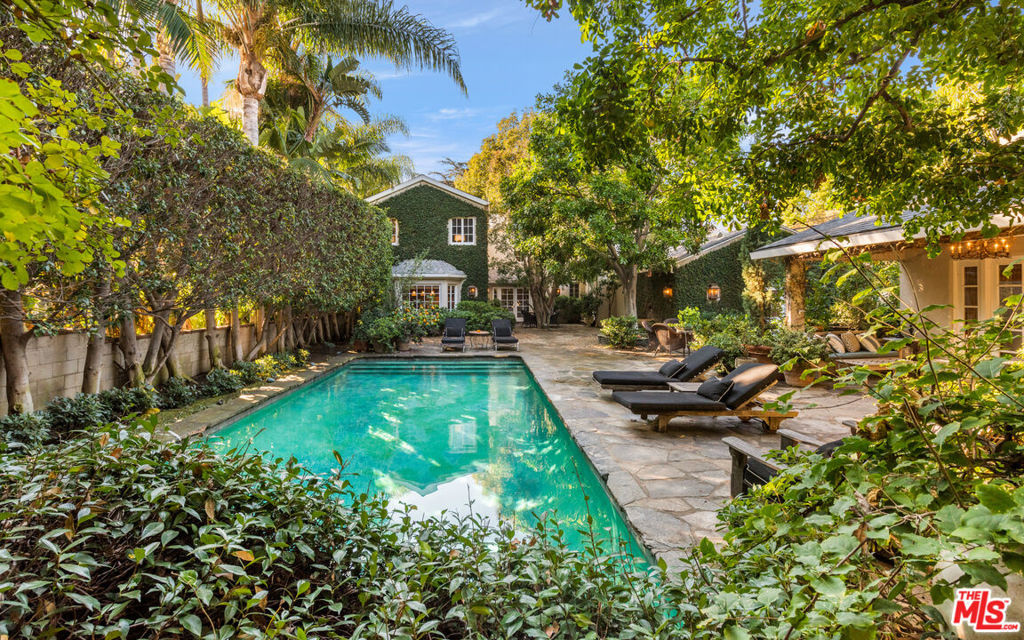 New Price! Elegant 1937 Traditional located on the premiere street of West Hollywood. Grand entry with original old-world detailing leads to stunning living room with dark rich hardwood floors, antique stone fireplace and French doors. Gracious sun-filled dining room, gourmet kitchen with dual eat-in areas. Large family/media room with 2nd fireplace and French doors that lead to the expansive yard. A bedroom suite and powder room complete the main level. Sweeping staircase leads to gorgeous primary suite with 3rd fireplace made of marble, sumptuous bathroom and large walk-in closet. There is an additional over-sized bedroom suite. Sensational resort-like yard with one bedroom guest house that contains a kitchen and 4th fireplace. Lush pool area with mature trees that offer complete privacy. 2-car garage. Magical living in the heart of the city!