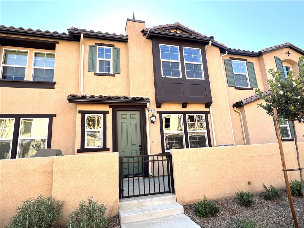 This elegant, two-story home is located in a beautiful new resort style community in South Ontario Ranch. Once going inside this 3 bedroom 2.5 bath home, discover an open floor plan with 9-ft. first-floor ceilings and luxury vinyl plank flooring at main living areas. Enjoy cooking in the stunning kitchen, which boasts quartz countertops, Whirlpool® stainless steel appliances and thermofoil cabinets. Relax in the spacious primary bedroom, which features plush carpeting, a walk-in closet and connecting bath that offers ceramic tile flooring, cultured marble countertops, oval undermount sinks and a walk-in shower. Additional highlights include a solar energy system, LED lighting, smart thermostat and tankless water heater to ensure uninterrupted comfort for hot water. The exterior of the home also features a water-efficient front yard which highlights the eco-friendly solar energy system. Also featured is an attached 2 car garage and driveway for additional parking convenience. Future community amenities include pool, spa, dog park, and pickleball. Easy access to I-15, I-10,91 and 60 Freeways. Close to shopping, the Ontario International Airport, great schools and Ontario Mills Mall are just a short drive away.