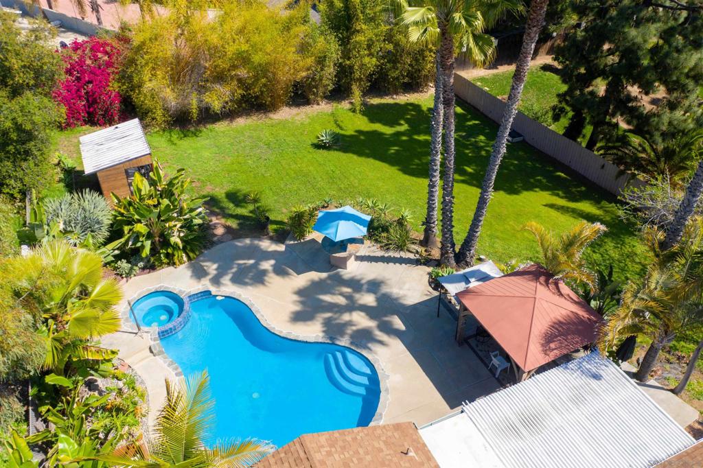 Discover this exceptional home nestled on a private, low-traffic drive, featuring charming hand-laid brick entry and ample parking options. This gem truly stands out! The spacious backyard boasts a sparkling pool and generous yard space, perfect for entertaining, outdoor play, or relaxing gatherings. Enjoy your happy hour at the built-in 32x13 outdoor bar and seating area, or unwind in your private cabin retreat beyond the pool. Utilize your 15x8 home office/craft room/storage inside the entry wall, a real plus for additional square footage. Perks for RV enthusiasts, there's a dedicated RV parking slab with electric hookup, sewer, and water—easy to connect—and extra space for a second RV and up to six vehicles within the hand laid brick driveway. The fully fenced property also features a convenient storage shed and built-in cabinets for all your storage needs. Inside, you'll find a cozy fireplace, charming mid-century kitchen with ample dining space, laundry area, and a spacious hall bath shared by two bedrooms. The primary suite offers an updated bathroom with relaxing newer Spa Tub. Modern upgrades include solar panels, pool refurbished in 2015, new AC and furnace installed in 2016, and recently replaced washing machine and dishwasher. Come find a combination of comfort, versatility, and style—ready for your next chapter!