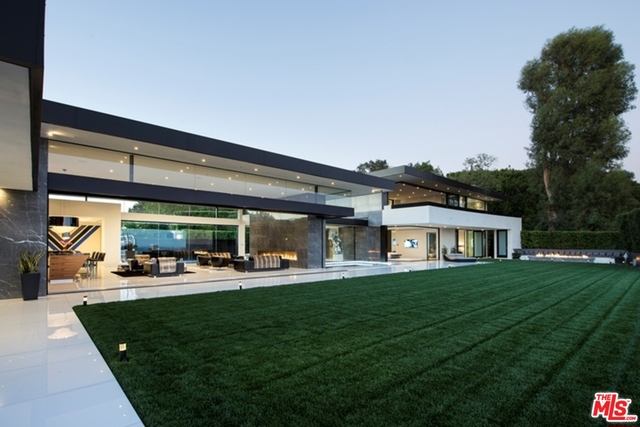 Behind private gates on one of the most coveted streets in the Platinum Triangle, this Paul McClean-designed contemporary masterpiece boasts panoramic city-to-ocean views beyond compare with a dramatic open floor plan and collapsible walls of glass for effortless indoor-outdoor living. Exquisite interiors include a staggering living room with motorized glass doors to an expansive outdoor entertaining area complete with a 90-foot infinity edge pool and grassy yard, as well as a full bar, Italian kitchen, media room, billiards room, gym with steam room, and wine cellar with thumbprint security access. A private master wing features dual showroom closets and opulent bathrooms with steam rooms, a full bar, office, and sliding walls of glass to a huge outdoor deck. A Crestron smart home system,10-car subterranean garage, staff quarters, catering kitchen, Listone Giordano hardwood floors, FIMES closets, and custom Italian furnishings complete this architectural gem in the hills of Bel Air.