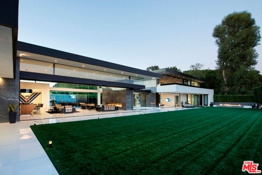 Behind private gates on one of the most coveted streets in the Platinum Triangle, this Paul McClean-designed contemporary masterpiece boasts panoramic city-to-ocean views beyond compare with a dramatic open floor plan and collapsible walls of glass for effortless indoor-outdoor living. Exquisite interiors include a staggering living room with motorized glass doors to an expansive outdoor entertaining area complete with a 90-foot infinity edge pool and grassy yard, as well as a full bar, Italian kitchen, media room, billiards room, gym with steam room, and wine cellar with thumbprint security access. A private master wing features dual showroom closets and opulent bathrooms with steam rooms, a full bar, office, and sliding walls of glass to a huge outdoor deck. A Crestron smart home system,10-car subterranean garage, staff quarters, catering kitchen, Listone Giordano hardwood floors, FIMES closets, and custom Italian furnishings complete this architectural gem in the hills of Bel Air.