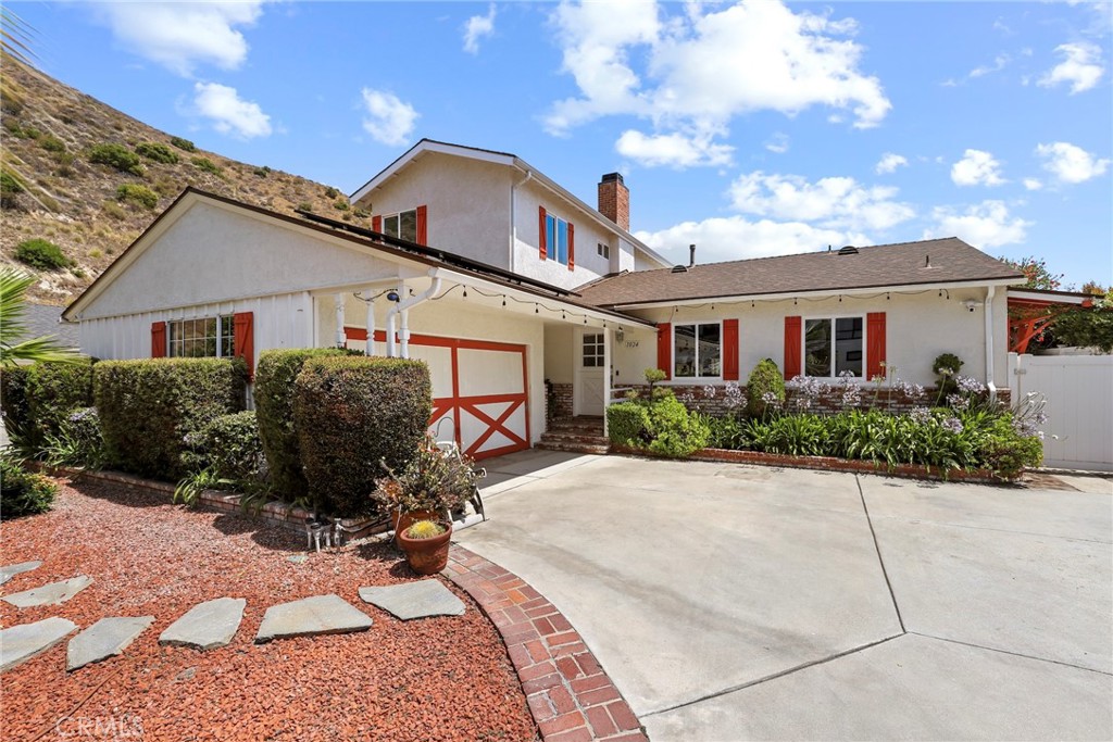 Welcome to 1024 Hamline Place, a beautifully updated traditional home located on a quiet cul-de-sac in the highly desirable Burbank Hills. This 5-bedroom, 3-bathroom home offers 2,240 sq ft of living space on a generous 8,967 sq ft lot, complete with major curb appeal, beautiful landscaping in the front and back, and a large RV-accessible driveway. The open floor plan features a spacious living room with a charming fireplace, a dining area, and a recently remodeled kitchen with modern white marble countertops, new appliances, and fresh paint throughout the home. Three bedrooms are conveniently located downstairs, perfect for a home office, guest suite, or multi-generational living, while upstairs you'll find two more bedrooms including a primary suite with sweeping views of the mountains and city. The backyard is an entertainer’s dream with a modern, heated infinity saltwater pool and jacuzzi overlooking stunning panoramic views, complete with a Tiki Bar and Bamboo Table for a true resort-style experience. Additional highlights include a large 2-car garage, owned solar panels, an artistic staircase, and fresh interior paint throughout. This is a rare opportunity to own a move-in-ready view home in one of Burbank’s most sought-after neighborhoods—don’t miss out!