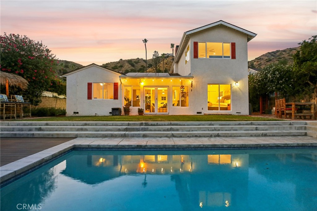 Welcome to 1024 Hamline Place, a beautifully updated traditional home located on a quiet cul-de-sac in the highly desirable Burbank Hills. This 5-bedroom, 3-bathroom home offers 2,240 sq ft of living space on a generous 8,967 sq ft lot, complete with major curb appeal, beautiful landscaping in the front and back, and a large RV-accessible driveway. The open floor plan features a spacious living room with a charming fireplace, a dining area, and a recently remodeled kitchen with modern white marble countertops, new appliances, and fresh paint throughout the home. Three bedrooms are conveniently located downstairs, perfect for a home office, guest suite, or multi-generational living, while upstairs you'll find two more bedrooms including a primary suite with sweeping views of the mountains and city. The backyard is an entertainer’s dream with a modern, heated infinity saltwater pool and jacuzzi overlooking stunning panoramic views, complete with a Tiki Bar and Bamboo Table for a true resort-style experience. Additional highlights include a large 2-car garage, owned solar panels, an artistic staircase, and fresh interior paint throughout. This is a rare opportunity to own a move-in-ready view home in one of Burbank’s most sought-after neighborhoods—don’t miss out!