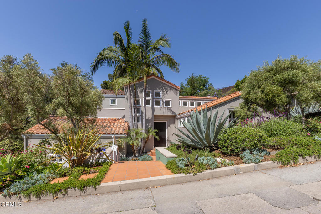 On the market for the very first time, this exceptional modern Spanish home--lovingly designed and built over decades by its owner-architect--is a rare blend of artistry, craftsmanship, and thoughtful design. Nestled within a charming 1930s character neighborhood, this light-filled residence embraces timeless Spanish architectural elements while offering the comfort and functionality of modern living. From the moment you step into the dramatic two-story foyer, flooded with natural light and graced by a Spanish-inspired staircase, the home reveals a rich tapestry of custom details: arched openings, bullnose plastered corners, an oversized custom front door, and a unique Cosanti doorbell. Vaulted ceilings crown both the living room and library, each with its own gas fireplace, creating a sense of openness and warmth throughout. Perfectly oriented for privacy and views, the home looks out over a heated saline pool and spa, surrounded by a mature, xeriscape garden with landscape lighting, automatic drip irrigation, and lush plantings including potted olive trees and succulents. Multiple French doors lead to a balcony and terraced flagstone patios--ideal for entertaining--with built-in BBQ and serene garden spaces shaded by olives, dogwood, and sequoias. The semi-open main floor includes a remodeled kitchen with high-end appliances including a Sub-Zero refrigerator and Wolf ovens, as well as spacious living areas and built-in storage throughout. The versatile library with walk-in closet and ensuite bath can easily serve as a fourth bedroom or a refined home office. Upstairs, the private primary suite offers vaulted ceilings, stunning sunset views, and a spa-like bathroom with cedar-lined walk-in closet. The lower level includes two additional bedrooms with custom built-ins, a full bathroom, family room, a 500-bottle wine closet, and a spacious laundry room with floor-to-ceiling storage. The attached two-car garage features epoxy floors and attic storage. Thoughtfully designed and artfully built, this is a rare opportunity to own a timeless architectural original.
