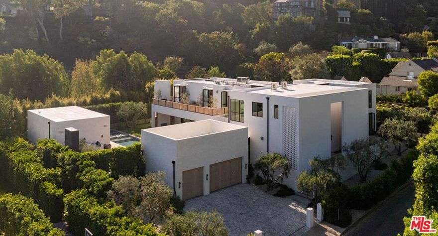 "FIVE FATHOMS"- The latest creation by celebrity designer Jae Omar and architect Eran Gispan, is a residence of lyrical beauty and organic architectural reverence. Set on a sprawling 20,000 square foot lot, this 9,800 square foot residence unfolds across five distinct structures, thoughtfully connected by glass-encased walkways that 'float' over meandering waterways. The interior aesthetic showcases Omar's signature 'organic modern' approach, featuring a textural symphony of sandblasted stone, vanishing walls of glass, and meticulously crafted white oak accents that converge in perfect harmony. The primary suite stands as a singular retreat, complete with a private library, a vast deck, and an ethereal stone-wrapped bathroom that is cloaked in natural light from strategic skylights that continue into the custom walk-in closets. Additional features include ADU, conceived as a serene wellness retreat, a  65-foot swimming pool adorned with a grand spa and cold plunge, expansive cobblestone terraces, multiple outdoor fireplaces, a fully equipped alfresco kitchen, state-of-the-art Dolby theatre and a cutting-edge security system with voice-activated infrared technology. 'FIVE FATHOMS' - A legacy of contemporary design and luxury living!