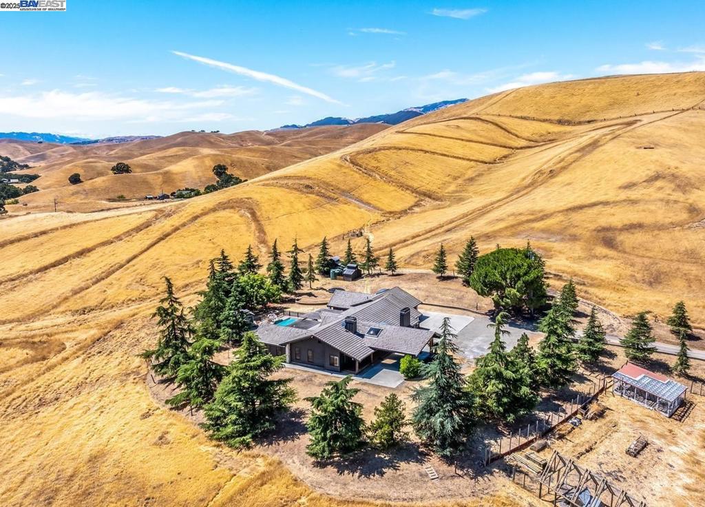 Behind a private gate, nearly 44 acres of scenic countryside surround this beautifully maintained single-level home at 8191 Highland Road. Offering approx. 3,000 sq ft, the 3-bed, 3-bath residence features spacious living areas, a remodeled kitchen, and serene views throughout. Enjoy the expansive terrace with pergola, pool, detached studio, and separate office loft—ideal for work or creative use. The land offers endless potential: pasture, vineyard, equestrian setup, or weekend escape. Additional highlights include a 2-car garage, carport, motor court, well, and multiple outbuildings. Located near shopping, freeway access, and the communities of Livermore, Pleasanton, Dublin, and Danville—yet far enough away to feel like your own private retreat.