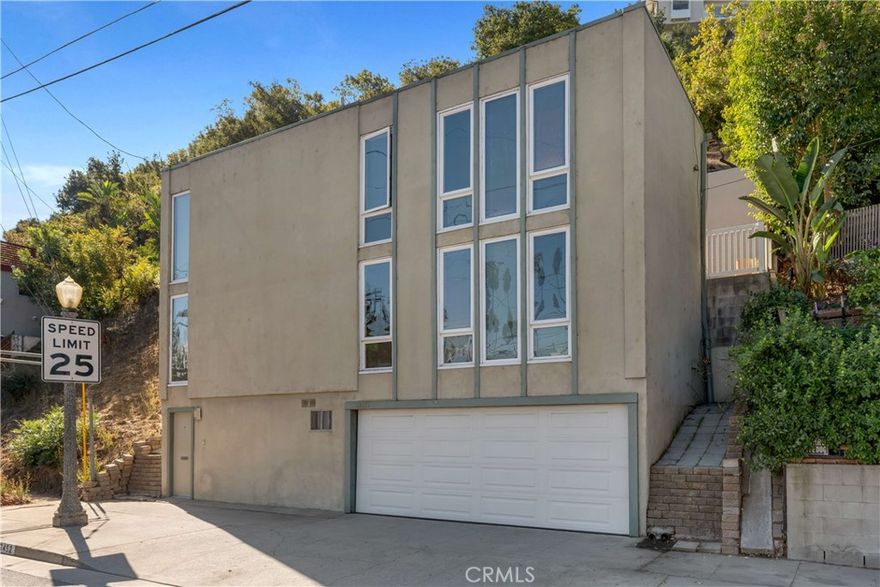 Located in Studio City’s highly sought-after Silver Triangle neighborhood south of Ventura Blvd and within the boundary of highly rated schools, including the award-winning Carpenter Elementary, this 2-bedroom, 1.5-bath home with a flexible bonus space presents an incredible opportunity to reimagine a property in one of the area’s most desirable enclaves. Enter the quaint foyer with staircase leading to the main living area, as well as access to a spacious bonus room and closet space—ideal for use as a home office, studio, gym, guest room, or simply additional storage. Just off the bonus space is a separate laundry area and with adjacent access to the 2-car attached garage. Upstairs, the main living and dining area showcases floor-to-ceiling dual-pane windows that fill the space with natural light while framing peaceful treetop, neighborhood, and city light views. A conveniently located powder bath serves this level, while the kitchen offers endless potential for a creative reimagining and modern redesign. On the upper level are two good-sized bedrooms that share an updated full hall bathroom. At the top of the staircase—just before the bedrooms—is a door leading directly to the rear outdoor space featuring sleek tile flooring and an abundance of sunlight while offering privacy with surrounding walls and high fencing. Beyond the rear block retaining wall, the lot continues further upslope, providing the potential opportunity to expand the home or create a multi-level outdoor retreat complete with a viewing deck to capture the sweeping mountain, hillside, and city light vistas. With nearby homes of similar floorplans recently renovated and commanding strong resale values, this property offers tremendous upside potential. Perfectly positioned near a wide range of popular dining, shopping, and entertainment destinations along trendy Ventura Blvd—including Pinz Bowling, Rocco’s Tavern, Granville, Sweet Lady Jane, Art’s Deli, and Salt & Straw—plus convenient proximity to Ralph’s, Erewhon, and other everyday essentials, like The UPS Store. Easy access to major thoroughfares such as Laurel Canyon, Coldwater Canyon, and the 101 and 170 freeways ensures a seamless connection to the Westside and beyond.