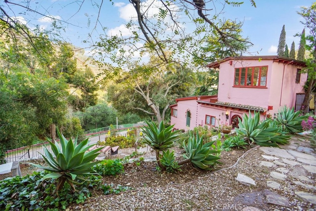 This house has everything that Topanga lifestyle has to offer. Beautiful, beamed, very high ceilings. Newly remodeled kitchen, with lots of bright light and high ceilings. Primary bedroom is found up a spiral staircase w/ remodeled ensuite bathroom that has a clawfoot tub. Remodeled downstairs bathroom features an entire wall of rose quartz, with sliding barn door. Sun room with tons of windows at front of home overlooks hills of Topanga. Washer/dryer inside home. Outdoor space is a must see - beautiful patio area under a wisteria trellis. Bonus space located in said lush garden. Outdoor shower and bath, this bonus space could be used as an art room, studio, or guest room, possibilities are endless. Plenty of street parking along the boulevard or on the upper street, Treasure Trail. Location is fantastic, walking distance to Cafe Mimosa, minutes from Downtown Topanga, stores and cafes like Hidden Treasures and Topanga Living Cafe.