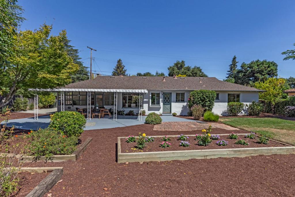 Located mere moments from downtown Los Altos, this classic ranch-style home boasts spacious rooms for entertaining, a quiet bedroom wing, and a huge park-like backyard. The living room features a focal-point fireplace and a large picture window overlooking the front yard. The dining room has views of the verdant yard with direct access to the kitchen for ideal flow and functionality. The kitchen sits in the heart of the home with a door to the covered patio and outdoor space. And to round out the public rooms, a lovely sunroom has two entire walls of windows and a glass door to the covered patio. Situated in a private wing of the home, two bedrooms enjoy wide windows, and the primary suite has a large closet and abundant natural light. Outside, a large partially-covered patio looks out over the landscaped grounds with numerous mature shade trees, a large raised bed, a brick patio, and a stretch of level lawn for play. A fantastic single-level floor plan and a large 11,662 square foot lot, with fabulous amenities and excellent schools nearby!