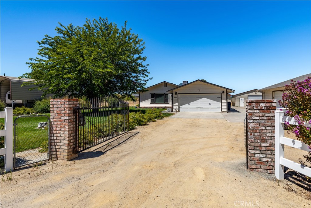 Welcome to Your Paso Robles Wine Country Retreat on Two Useable Acres with Multiple Garages & Shop! This charming single-story home sits behind its own private gate on approximately 2 flat acres, offering privacy, space, and room to roam. With ~1,232 square feet of living space, the home features 3 bedrooms, 2 bathrooms, and both an attached 2 car garage plus a detached 2-car garage with workshop. Additionally, there’s a shop building, a shed, plus covered RV parking! A spacious front yard with lush green grass and a beautiful shade tree creates a welcoming first impression. Inside, you'll find vinyl plank flooring in the main living areas and cozy carpet in the bedrooms. The kitchen offers stainless steel appliances, quartz countertops, ample cabinetry for storage, and a breakfast bar that opens to the dining area, where sliding doors lead to a covered back patio - perfect for relaxing on warm summer evenings. The primary suite includes its own private en suite bath. The large shop and separate shed offer additional flexibility for hobbies, storage, or workspaces. Other amenities added over the years include a newer roof on the house, owned solar, and an updated HVAC system. With plenty of room for animals or personal projects, and just minutes from Highway 101, award-winning wineries, and local amenities, this property blends country living with everyday convenience. Come make it your own!