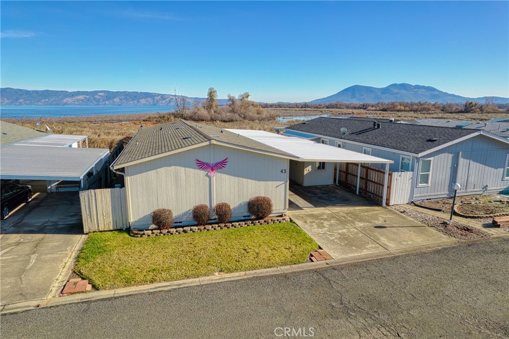 This property is a unique opportunity, offering the benefits of lakefront living without the associated costs of space rent that are typical in manufactured home parks. The home is situated in Lakeport, providing stunning views of Clearlake, renowned for its excellent boating and fishing. It includes a gangplank and a floating boat dock, ideal for boating enthusiasts. The patio, offering breathtaking views, provides an excellent vantage point for wildlife observation and relaxation. It's a well-maintained manufactured home with recent updates, including siding, kitchen appliances, cabinets, and newer carpet, enhancing both aesthetics and functionality. The house includes 2 bedrooms and 2 bathrooms, catering to the needs of a family or individuals who may require extra space for guests or a home office. A spacious laundry room that also includes a desk area, providing space for organization or work tasks. The living area is expansive, supplemented with two dining areas, making it ideal for entertaining or family gatherings. The home is equipped with heating and air conditioning, including a monitor heater, ensuring comfort in all seasons. The presence of a covered carport ensures protection for vehicles against weather elements. There are two storage sheds on the property, which provide ample space for storing tools, outdoor equipment, or seasonal items. While a homeowners association (HOA) fee applies, it might contribute to shared community amenities and maintenance, adding value to the residential experience. No space rent is required, which can translate into financial savings compared to traditional manufactured home parks.