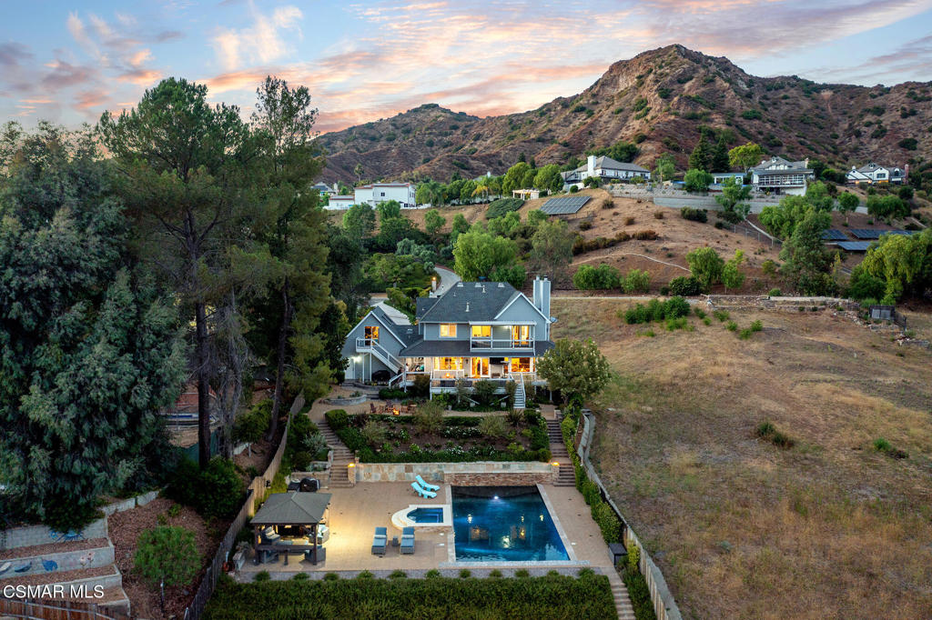 Welcome to 29728 Triunfo Dr., an exquisite property nestled in the heart of Agoura Hills and the Santa Monica Mountains. This stunning residence offers a perfect blend of luxury, comfort, and serene living, making it an ideal home for those seeking tranquility without sacrificing convenience. As you approach the property, you'll be captivated by its charming curb appeal, magnificent canyon views, lush landscaping and a grand entrance. Situated on more than half an acre, this spacious almost 4,300 square foot three story home boasts 6 bedrooms, and 3.5 bathrooms, providing ample space for family, guests and entertaining. Inside, you'll find a truly incredible floor plan with a sweeping staircase, high ceilings and large windows that flood the space with natural light and breathtaking canyon views. The gourmet kitchen is a chef's dream, equipped with top-of-the-line stainless steel appliances, custom cabinetry, and a large island perfect for entertaining. Adjacent to the kitchen is a cozy family room with a fireplace, creating a warm and inviting atmosphere. The primary suite is a true retreat, with access to a scenic balcony that overlooks the lush grounds of your flawless backyard, unobstructed views of the Santa Monica Mountain Range, two walk in closets, and completed with a luxurious en-suite spa inspired bathroom featuring a soaking tub, dual vanities, heated floors and a walk-in steam shower. Additional bedrooms are generously sized and offer plenty of closet space providing family members or guests with their own haven of comfort and privacy. Step outside to your private backyard oasis. Immerse yourself in the enchanting surroundings as you lounge by the sparkling copper plumbed pool, unwind in the spa, or bask in the sun on the sprawling patio. Enjoy the wrap around porch for outdoor dining and relaxation. The meticulously landscaped yard provides a serene backdrop and ensures privacy. Located in the desirable community of Agoura Hills, this property is conveniently close to top-rated schools, shopping, dining, and recreational activities. Enjoy easy access to scenic hiking trails, parks, and the stunning beaches of Malibu.
