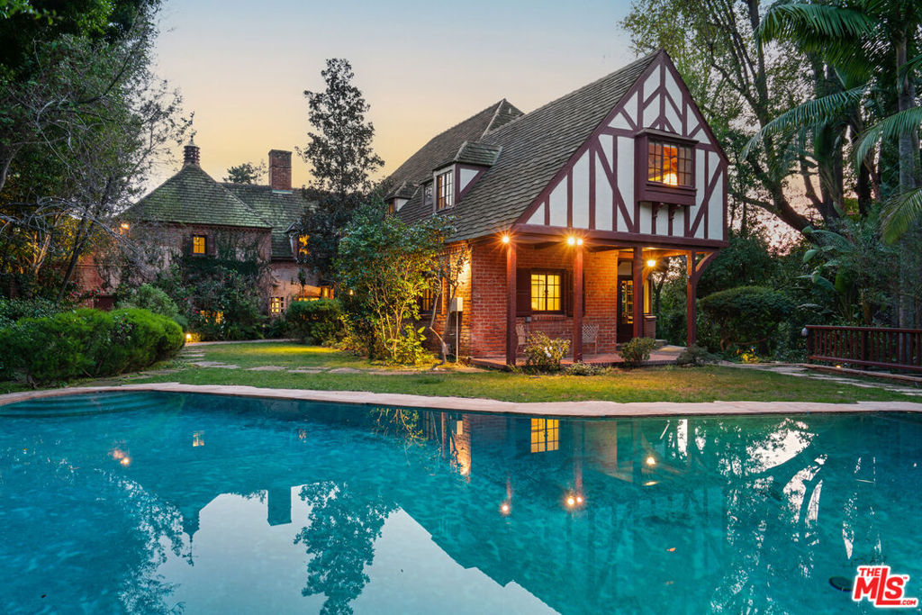 First time on market in 48 years: a classic, private, gated & secluded Tudor Revival in prime Los Feliz. Enchanted Country English Manor w/5 beds+6 baths designed by architect Gerard Colcord for legendary Chandler family son Philip. Ingeniously sited on two parcels, Chandler House is an optimum backdrop for both indoor & outdoor living, combining an exemplary floor plan & garden layout. First floor: foyer; reception ensuite w/powder; paneled library w/FP; family room w/FP; gracious living w/FP; formal dining room; large kitchen; & breakfast room. Service wing incorporates maid's ensuite, laundry & back staircase. Second floor: upstairs landing; grand primary ensuite w/FP; bedroom+bath; beloved Captain's theme bedroom+bath; bedroom+adjacent bath. Gardens provide a lush oasis w/mature trees, sitting areas, dining terraces, b-b-q, & playground. Huge pool+gazebo (w/storage basement). Two-car direct access garage w/storage. Updated kitchen and primary bath. Abundant storage & secret panel closets throughout. Built by premier Warmington Construction Company in 1936. Featured in "Architectural Digest" in 1938. Seldom do estates of this caliber & pedigree enter the marketplace: an architectural, character-rich dream house. Quite simply, a gem.