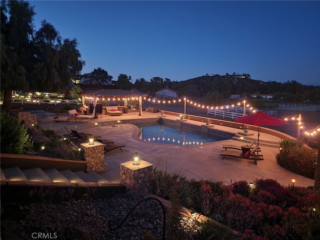 The Crown Jewel of La Cresta | Multi-Gen Equestrian Estate! Welcome home to one of the finest equestrian parcels with resort-style living in La Cresta that is fully fenced and tucked away on a quiet cul-de-sac with direct access to riding trails. The property runs on a 62 panel FULLY-OWNED solar system and features 2 beautiful single-story homes, custom barn, 3,498 sf workshop/car garage with MX-10 ACX auto lift and 2 large roll-up doors that fit full-size RV, solar-heated swimming pool with waterfalls, 6 person above ground spa, outdoor barbeque kitchen, cabana at pool area, 2 fire pits, chicken coops, above ground gardens, two 5,000 gallon water storage tanks and 5.14 FULLY useable acres! For the horse enthusiast, the property boasts a custom shedrow 2 stall barn with tack room, and feed-storage room, automatic waterers and connected turn out stalls. There are currently 3 horse pastures and a round pen with room to add more! The main home is 2,686 sf featuring 3 bedrooms, 3 baths, built-in office, gym/game room, open concept family room and kitchen with top of the line Stainless Steel appliances, breakfast nook, formal dining room, oversized 2 car garage, plus additional detached 2.5 car garage. The 2nd home was built in 2007 is 1,737 sq ft with 3 bedrooms, 2 full baths, attached 2 car garage and office. This property is perfect for multi-generational living, or rental income. Both homes have panoramic hillside and mountain views perfect for enjoying La Cresta sunrises & sunsets. This quiet and secluded property is the epitome of peace and tranquility, while being minutes away from award-winning schools, shopping, and freeway access. Must see in person to appreciate all this property has to offer! Square footage not taped, buyer to verify.