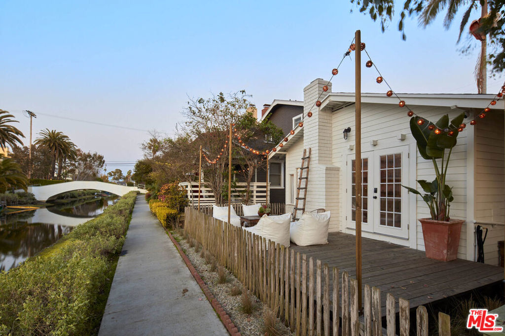 Incredible Venice Canal Jewel Box - Tucked along the iconic Venice Canals, this charming bungalow is a rare offering - a true beachside retreat and an ideal pied-a-terre in one of Los Angeles' most coveted coastal enclaves. With its serene setting and timeless charm, this thoughtfully updated home offers a unique slice of SoCal living just moments from the sand. Step inside to find a light-filled open living and dining space, warmed by a gas fireplace and framed by French doors that open to a spacious canal-front deck. It's the perfect place to lounge, entertain, or dine al fresco while enjoying breezes off the Pacific and magical sunsets reflected on the water. The home has been tastefully updated with new vinyl plank flooring, modern appliances, fresh interior and exterior paint, stylish lighting, and a tadelakt bath that adds a bespoke designer touch. The French-style front door and updated finishes bring a crisp, coastal feel throughout. Outside, the fenced yard features newly landscaped grounds and a grassy area perfect for gardening, relaxation, or creative expansion. Two parking spaces add convenience in this high-demand location. Whether you're seeking a weekend getaway, a low-maintenance home, or a property with future potential, this canal-side bungalow delivers. Just a short stroll to Abbot Kinney, the beach, parks, and top dining and shopping, it's a rare opportunity to own a peaceful yet vibrant slice of Venice.