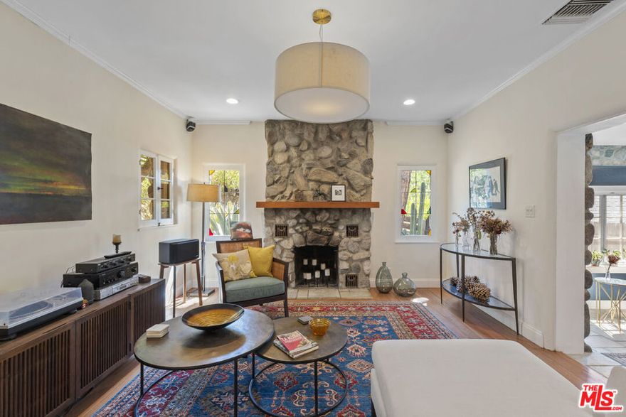 Elevated above the street and set back for maximum privacy, this exceptional residence offers a serene retreat on an expansive 8,871 sq. ft. lot. This beautifully updated 1932 stone house combines a rare blend of original details and modern updates providing ultimate comfort with direct access to the natural beauty of the Verdugo Mountains.  Behind its gated entry, you step into the fully enclosed grounds where you'll discover a spacious flat yard and multiple outdoor living spaces, including a covered dining area perfect for entertaining or relaxing in total seclusion. A private rear gate opens onto a trail providing effortless access to miles of hiking and recreation. Inside, the home retains its original character while thoughtfully incorporating high-end updates.  Upstairs the remodeled primary suite is a luxurious sanctuary, featuring vaulted ceilings, high quality Marvin Integrity windows, mountain views, a beautifully updated bathroom with Cle tile, a walk-in closet, ceiling fan, remote-controlled blinds, and its own dedicated HVAC zone for personalized comfort. On the main floor the updated kitchen offers extensive, recently redone cabinets, stainless appliances and a built-in pantry cleverly tucked away beneath the staircase. The kitchen connects to a stunning sundrenched dining room with built-in shelves and two walls of windows and doors to the outside, creating a seamless flow between indoor and outdoor living. The spacious living room features a dramatic floor-to-ceiling stone fireplace and stained-glass windows. At the far end of the house the generous secondary bedroom with walk-in closet connects to a den with built-in shelves and another full bathroom allowing it to easily function as a second primary suite.  A detached 400 sq ft studio with half bath offers infinite possibilities  whether as a creative space, home office, guest quarters, gym or an easily convertible ADU. The studio features new hardwood flooring, a separate HVAC system, tankless water heater and attic storage. The oversized two-car garage has ample storage and 220v power for EV charging.  Other recent upgrades include new roofs and gutters, and a new all-electric HVAC system. This magical property can feel like a world of its own but is just minutes from all the restaurants and shopping of downtown Burbank and a short 15-minute commute to major studios and much of the entertainment industry.  The property offers access to Burbank's top-rated school district and benefits from utility rates less than half of LADWP's.  Don't miss this rare opportunity to join the historical Country Club neighborhood, one of Burbank's most desirable settings.