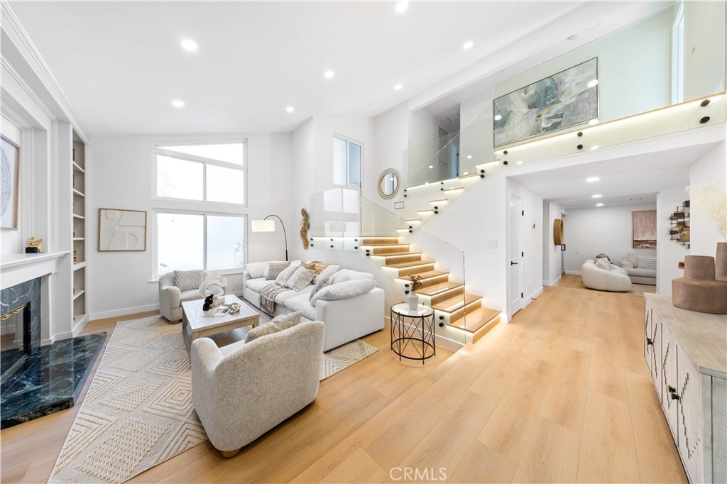 A rare, fully reimagined designer home in Orange County—truly turnkey and custom rebuilt to perfection. Located in the prestigious Montbury on the Hill community in North Lake Forest, this stunning residence was transformed by a Newport Beach-based professional designer focused on luxury, functionality, and signature style. For buyers tired of cookie-cutter tract homes, this is a custom alternative that stands out in every way. Among its most exceptional features are dual primary suites—one on each level—ideal for multigenerational living, guest flexibility, or a dedicated office. Natural light floods the home through soaring ceilings and expansive windows, creating a warm, open, and elevated atmosphere. The chef’s kitchen features GE Café appliances, Taj Mahal quartz countertops, custom cabinetry, and integrated LED light strips that extend into the closets and staircase—every inch thoughtfully crafted. A spacious family room offers a custom media wall, built-ins, and an open lounge with a transparent glass wine display. The downstairs suite includes sliding-door access to the backyard, a spa-style bath with a freestanding tub, dual rain-head shower, double vanities, and a large walk-in closet that can double as a dressing room or office. Upstairs, a second primary suite offers a fireplace, full bath, and large sitting area. Two additional bedrooms feature custom closets and share a dual-sink bath. Upgrades include new PEX repiping, dual-pane energy-efficient windows and sliders, smart LED lighting with dimmers, a modern tempered glass staircase, new flooring, new doors and hardware, fully customized closets with lighting, and a brand-new roof currently being installed. Two fireplaces—one in the living room and one in the upstairs suite—add warmth and charm. The landscaped backyard features a covered patio, pool, and expansive lawn ideal for entertaining. A 3-car garage, extended driveway, and separate laundry room offer everyday convenience. The community includes tennis and pickleball courts, scenic equestrian and hiking trails, and well-maintained parks. Conveniently located near the 241 Toll Road and I-5 freeway access, and surrounded by well-rated public and private schools. Renovated to the highest standards, this home has not been occupied since its transformation—show with confidence; there’s truly nothing else like it on the market.