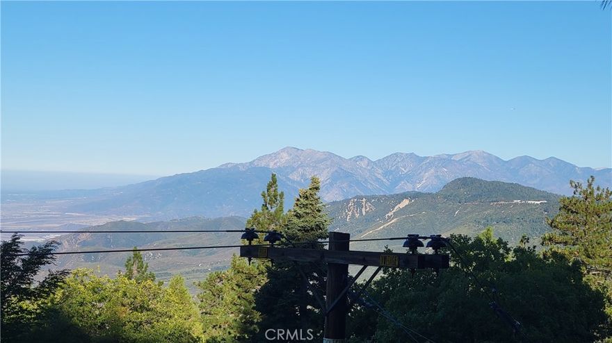Welcome to 1933 Willow Drive, where you'll feel on top of the world! This popular A frame style cabin has panoramic views of the ocean, Mt Baldy, the Inland Empire valley, Anaheim Hills and everything in between.

With coveted vaulted ceilings in the living room and loft area, this cabin is the epitome of chalet living. Large picture windows showcase the gorgeous views and a Swedish fireplace will keep you toasty on winter nights. There's a bedroom on the main floor, as well as a full bathroom. Downstairs is a game room/family room or additional sleeping space, you choose! Three nice sized decks make comfortable outdoor seating to enjoy too.