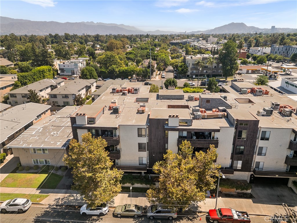 Prime Sherman Oaks setting—near Erewhon, one of L.A.’s most popular markets. Top-floor corner residence—Penthouse style living condo—with windows on three sides and western exposure delivers abundant natural light and volume. The single-level “penthouse” layout showcases approx. 20’ ceilings, an expansive living room with wet bar, a separate fireplace lounge/den, and a private covered balcony among the treetops. Generous dining area for gatherings. The bright primary suite offers three closets, including a walk-in; the updated bath features dual vanities and a spa tub. Secondary bedroom has direct balcony access. In-unit washer/dryer. Controlled-access community with pool/spa and landscaped atriums; HOA notes a newer roof. Subterranean garage with two secured tandem spaces (per HOA). Convenient to Erewhon, Whole Foods, Beeman Park, Westfield Fashion Square, local dining, and 101 access.