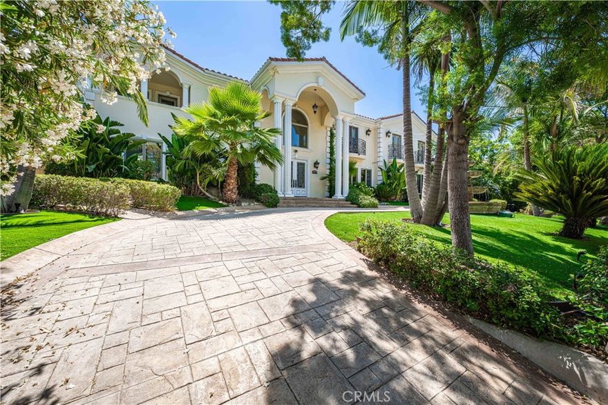 WOW ONLY $568 PER FOOT FOR SUCH AN INCREDIBLE HOME!! !Prestigious Tarzana Estate – South of Ventura Blvd – Timeless Luxury & Exceptional Privacy. Experience the elegance, comfort, and grandeur of this pristine 6844 sqft estate set behind gates on a prime, private lot in one of Tarzana’s most coveted neighborhoods. From the moment you arrive, the circular motor court framed by swaying palms and a stunning central fountain sets the tone for an extraordinary living experience. Step inside the 25-foot two-story foyer and feel the warmth and sophistication of a home designed for both lavish entertaining and peaceful everyday living. Every room exudes classic charm, from the multiple formal living and dining spaces to the two family rooms with cozy fireplaces. The chef’s kitchen is a dream - complete with Viking range, dual dishwashers, built-in refrigerator, walk-in and butler’s pantries, and a large center island perfect for gatherings. French doors open to a lush entertainer’s backyard featuring covered patios, a gourmet outdoor kitchen, private bathroom with shower, rock waterfall pond, shaded pavilion, grape arbor, synthetic lawn, and mature fruit trees - all creating a resort-like atmosphere you’ll never want to leave. The flexible floor plan offers a private downstairs guest wing - ideal for visitors or a home office, plus four en-suite bedrooms upstairs, each with walk-in closets and private terraces. The primary suite is your personal sanctuary, featuring a sitting room/gym with kitchenette, dual walk-in closets, private balcony, two fireplaces, and a spa-inspired bath with jetted tub, steam shower, and Juliet balconies. With parking for 10+ vehicles, a gated 4-car garage, 11.5FT ceilings with lift access for car collectors (with optional guest quarters or income potential), two laundry rooms, 2 powder rooms  whole-house water filtration, and impeccable finishes throughout - this home offers an unbeatable combination of scale, privacy, and value. Just moments from local markets, fine dining, boutiques, and places of worship, this is a rare opportunity to own one of Tarzana’s most distinguished estates.