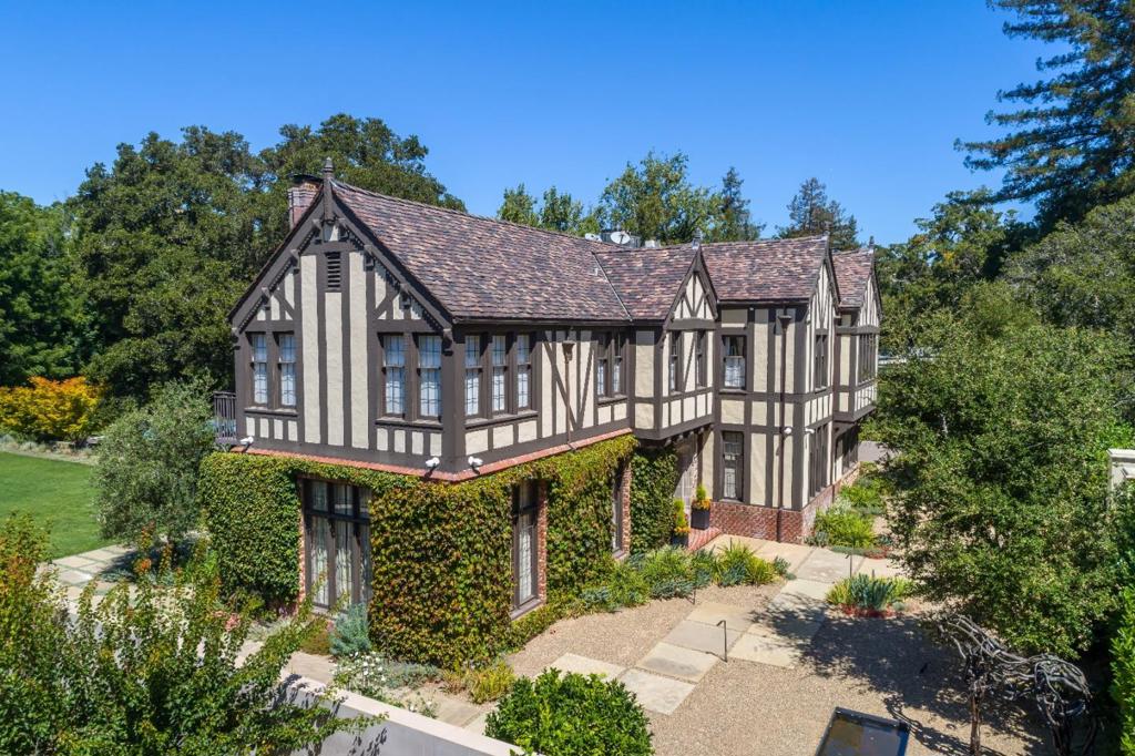 Stunning Tudor style estate offers thoroughly modern amenities enveloped in historically significant architecture located on approximately 2 flat acres on one of Hillsborough's most desirable streets. This remodeled home features 7 bedrooms, 6 baths & 3 half baths, library, home offices, custom home theater, gourmet kitchen with spacious eating room and expansive family room. Plus an updated one bedroom, two bath guest house. The spectacular private grounds include a vast lawn area, pool, spa, heated outdoor patio area, outdoor kitchen, firepit, tennis court and vegetable garden.