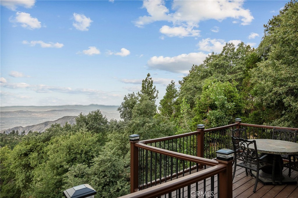 Ever wonder why this area is called 'Rim of the World'? Check out the VIEW on this amazing offering in Running Springs and you'll understand. From the ocean to the Anaheim Hills to Lake Matthews, you can take it all in through the gorgeous windows of this wonderful mountain home. At night, enjoy the transition to sunsets and city lights. With no houses behind you, these views will be yours for decades too.
Having been custom built by its current owner, this beautiful home has all the signs of love and care and virtually no signs of wear and tear. It's ready for you to come with your suitcase and start making memories. There's a bedroom and a full bathroom on each floor for everyone's privacy and space. The main floor features vaulted tongue and groove ceilings, picture windows and a warm wood stove. Upstairs is currently the primary retreat with a luxurious bathroom fit for your relaxation. The lowest level of the house is a bonus den space that is currently a game room with wet bar and pool table. This is where the fun happens on game day! You'll also find the third bedroom and bathroom here. Two decks to absorb the views day or night also are featured at 2477 Spring Oak.
Don't miss this exceptional home on your next tour!