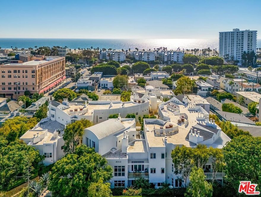 Stunning Designer-Renovated Townhome Just Blocks from the Beach! Welcome to this exceptional two-story corner townhome in Santa Monica's coveted Seaview Collectionan architecturally striking community just one block from the vibrant cafes, boutiques, and restaurants of Main Street and only three blocks from the beach. Perched on the 2nd and 3rd floors overlooking 2nd Street, this residence enjoys daily ocean breezes, gorgeous sunsets, and two expansive west-facing patios for true indoor-outdoor living. Step inside to a bright, airy living room featuring refinished hardwood floors, a gas fireplace, a custom floor-to-ceiling built-in bookcase, and dramatic floor-to-ceiling windows and doors that open to a large private patio. The brand-new custom gourmet kitchen is a chef's dream, showcasing marbled quartz countertops, designer cabinetry, a large center island with Viking gas range, professional-grade Viking appliances, and a handcrafted Shaws of England fireclay farmhouse sink by ROHL. Thoughtfully selected details include Schoolhouse Electric lighting and hardware, solid brass California Faucets fixtures, and exquisite encaustic cement tile from Cle Tile, each color individually mixed by craftspeople. The luxurious primary suite offers its own gas fireplace, glass doors to a private patio, generous walk-in closets, and a spa-inspired bathroom with a custom-sized Americh soaking tub, tiled shower, Toto toilet, motion-sensor under-vanity lighting, and a floating walnut Lacava vanity made from sustainably sourced wood. Additional highlights include updated central A/C and heat, a laundry room with Wi-Fi-capable washer and dryer, gated side-by-side parking in a prime location, plus extra storage in the garage. With three private outdoor spaces, incredible indoor-outdoor flow, and an unbeatable location a few short blocks from the sand, shops, and nightlife, and a short bike ride to Whole Foods, Rose Avenue, and Abbot Kinney Blvd. This rare townhome perfectly blends sophisticated design with the best of beachside living.