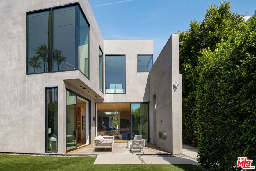 An architecturally striking modern compound set on an expansive private lot in prime Beverly Grove, offered fully furnished and currently leased at $35,000 per month, providing immediate in-place income. Designed for elevated indoor-outdoor living, this resort-style contemporary smart home features an open floor plan, wide-plank oak flooring, and floor-to-ceiling glass that delivers strong natural light and enduring tenant appeal.The main level is optimized for both functionality and entertaining, anchored by a fire-sided living area, formal dining space, and a chef's kitchen with premium stainless-steel appliances that opens directly to curated outdoor entertaining areas. Gated and private, the backyard retreat includes a custom pool and spa with multiple lounge areas, enhancing rental desirability and long-term value. Floating wood staircases lead to the upper level, where the primary suite offers a fireplace, floor-to-ceiling windows, private patio, and spa-like bath. Two additional en-suite bedrooms and a dedicated laundry room complete the upper level.A rooftop deck with panoramic city views, dining and lounge areas, and a wet bar further elevates the property's income profile and competitive positioning within the luxury rental market. Ideally located moments from The Grove, Beverly Center, world-class dining, shopping, and nightlife, with convenient access to the Sunset Strip and major freeways, this asset represents a rare opportunity to acquire a high-quality, stabilized luxury rental in one of Los Angeles' most consistently high-demand neighborhoods.