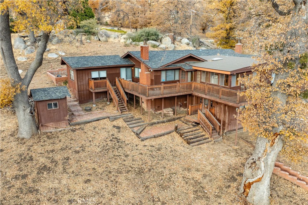 Welcome to 26601 Deertrail Drive, a serene mountain retreat located in a secure gated community. This 4-bedroom, 2-bathroom home spans 2,633 sq. ft. and is situated on an expansive 4.21-acre lot. Upon entering, you are greeted by a spacious great room featuring a wood-burning fireplace, hardwood floors, and large windows that frame stunning views of the surrounding mountains. The wood beam ceilings add an elegant rustic touch, creating a warm and inviting ambiance.Upstairs, the home features a thoughtfully designed open-concept kitchen with uniquely beautiful tile countertops, seamlessly flowing into the dining room with its charming brick archways. The adjacent living room offers a second fireplace, creating a cozy atmosphere perfect for gathering with family or entertaining guests. The outdoor amenities are equally impressive, featuring a large firepit area with built-in seating, ideal for hosting friends or enjoying quiet evenings under the stars. The expansive 4.21-acre property offers endless opportunities for outdoor activities, including hiking and exploring the natural beauty of the area. The tranquil surroundings make this property a perfect escape from city life while still offering modern conveniences. This is a trust sale and is being sold in as-is condition. Please contact the Premiere Estates team for additional documents and disclosures. Schedule your showing today to experience this remarkable mountain home!