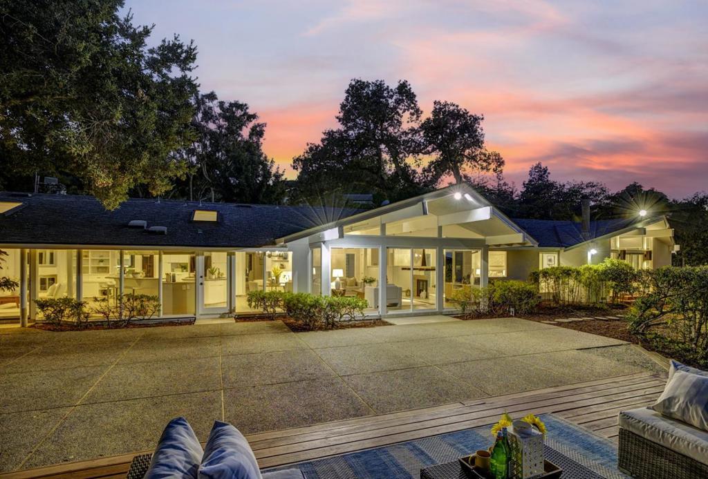 Experience luxury living in this beautifully appointed 5-bed, 2.5-bath home in sought-after Los Altos Hills. A private gated entrance on a cul-de-sac off Magdalena Rd. leads to an acre lot with a serene, park-like setting & mountain views, perfect for outdoor living. The exceptional mid century modern layout epitomizes luxury & ease of indoor/outdoor entertaining. Inside, discover a thoughtfully designed open floor plan with a formal living rm, fireplace & open beam ceilings, flowing seamlessly into a gracious dining room ideal for gatherings. Updated & open concept kitchen embraces the outdoors & features ample stone countertops, high-end appliances & a breakfast nook. Adjacent is a family room & media room with a half bath expandable to full-bath, perfect for an au pair or 5th bedroom. Each of the other 4 bdrms has its own charm, including a primary suite with a jaw dropping view, spa-like bath, stall shower, and soaking tub. Features freshly painted, AC, new lighting & 3-car attached garage w/ storage. Another bonus is this home is on city sewer. Grounds offer mature trees, multiple patio areas & more room to build on the expansive acre+ lot. Convenient yet quiet location is close to top rated schools, central Los Altos shops, restaurants, HWY 280, & more