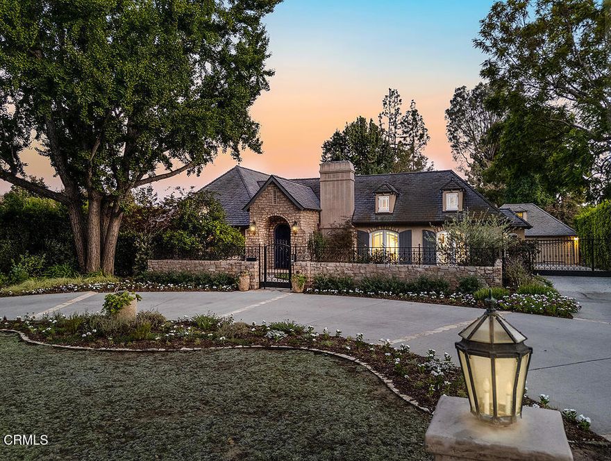 An extraordinary opportunity to own a fully restored single- story French Normandy estate, set on expansive park-like grounds. Thoughtfully re-imagined for modern refined entertaining and effortless daily living, this architectural estate offers the quintessential, and highly desired California indoor-outdoor lifestyle.The sunlit living room--anchored by a dramatic fireplace and beamed ceiling creates an inviting focal point. A formal dining room with French doors opens to the front gardens, while the gourmet kitchen, equipped with Wolf and Sub-Zero appliances, offers abundant cabinetry and a convenient adjoining laundry area. An adjacent and comfortable family room extends to a private patio overlooking the sweeping grounds. The main house features three bedrooms and four bathrooms including a spacious primary suite and spa-like bath with double sinks, a separate tub and shower and a large walk-in closet. Two additional bedrooms, one currently used as a spacious wood paneled executive office with a built-in desk, bookcases, and cupboards, share a beautifully appointed full bath to complete the private wing.A detached convertible guest house/office crowns the garage, providing a versatile 700-square-foot space with a three-quarter bath and sauna below.The estate's expansive grounds feature a grand and lush central lawn, mature shade trees, and multiple inviting patios. A spacious covered barbecue pavilion forms the perfect backdrop for 'al fresco' dining and memorable gatherings.