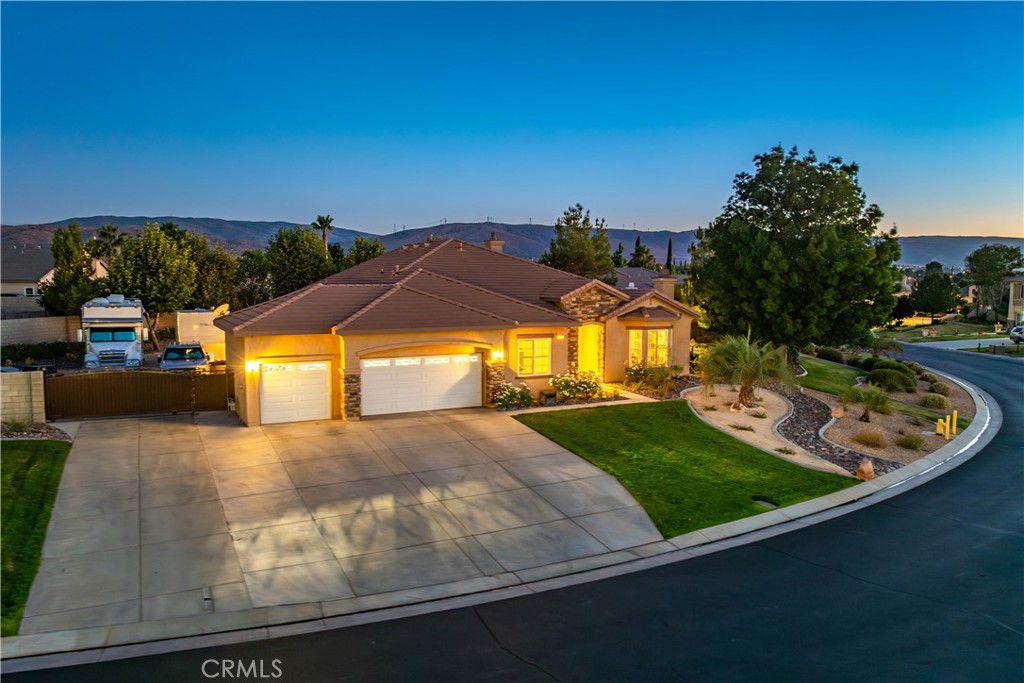 ***LIVE BEAUTIFULLY*** Welcome to an exceptional residence in the prestigious gated community of Portofino Estates in Quartz Hill. This nearly 3,000 square foot, five-bedroom, three-bathroom estate has been thoughtfully updated to combine luxury, comfort, and modern design in one stunning package. From the moment you enter, the attention to detail is unmistakable. The heart of the home is the expansive kitchen and great room, fully remodeled in 2023 to impress even the most discerning chef. Custom wood cabinetry extends to the ceiling with all-drawer base units for optimal storage, accented by Fantasy Lux Quartzite counters and backsplash, including a waterfall-edge island. The kitchen is equipped with premium Wolf appliances, including a 30” M Series double oven, a 36” professional gas cooktop with a Modern Aire hood, a 24” beverage center, a 15” wine cooler, and a 24” transitional drawer microwave. A Franke 16-gauge stainless steel work center sink anchors the space, while a walk-in pantry with stained wood shelving and custom drawer organizers adds practicality and elegance. The primary suite is a private retreat, featuring a spa-like bathroom remodeled in 2021 with a 9-foot custom vanity, Calacatta Bronze Quartzite countertops, Brizo fixtures, a 66” stone resin soaking tub, and a walk-in shower. The guest bath and laundry room, fully updated in 2025, reflect the same level of craftsmanship with 24x48 tile, marble herringbone accents, a 72” LED mirror with built-in vanity storage, and sleek quartz countertops. Step outside to a beautifully refreshed exterior. A 17-foot motorized rolling gate opens to a 30’ x 67’ RV pad complete with 30-amp electrical service and sewer access. The professionally repainted exterior is complemented by a fresh xeriscape front yard and newly refreshed decomposed granite in the backyard, all enhanced by a massive covered patio spanning three sections—perfect for outdoor living and entertaining. Additional features include a three-zone AC system installed in 2018, a new Goodman 3-ton furnace added in 2023, and a Kinetico water softener system for enhanced water quality. Blending timeless upgrades with thoughtful design, this Portofino Estates home offers luxurious living in one of Quartz Hill’s most desirable communities. It’s more than just a home—it’s a lifestyle.