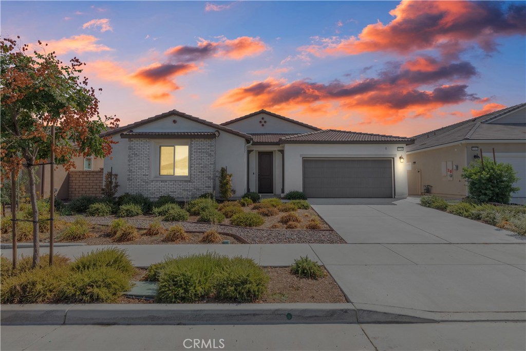Featuring a gorgeous Menifee single level built in 2021 by Richmond American. Located in the Braverde community, this home provides four nice-sized bedrooms, a dedicated office with double glass doors, 3 full bathrooms, a powder room and a breathtaking kitchen with soft close doors and drawers, deep drawers for pots and pans, a lazy Susan to utilize space that is too often wasted, a walk in pantry, and an island with a bar top with availability for 6+ guests. The chandelier in the dining area is a beautiful choice for the dining area. The wood-looking plank tile through the hall and common living areas and office are set in a Chevron pattern. The tile floor complements the tile backsplash in the kitchen. The handles and pulls in the kitchen are brushed gold and match the upgraded white, wifi appliances. Forget to start the dishwasher? You can do it from your phone. Quality and functionality were prioritized by the seller when the finishings were selected. Notice the built-in surround sound speakers in the great room? Or the bright great room and kitchen which both have upgraded lighting packages. The primary suite also has additional lighting and is located by the great room, separate from the other three bedrooms and office, providing more quiet time and privacy. The Primary bathroom is spa-like with a shower enclosure that is upgraded, and the oversized deep bathtub is tempting at the end of a long day. Imagine lovely with an upgraded glass shower enclosure, oversized tub, dual vanities, water closet, and well designed walk-in closet. The flat black fixtures are in all of the bathrooms, adding contrast with the white countertops. The exterior of the home is low maintenance. The front yard was designed with desert-tolerant landscaping. The back was professionally designed and installed, including the concrete patio off of the dining area and artificial turf in the backyard. The home has leased solar, at only $135.46/month, which helps to offset the electricity bills. If you haven't been to the Braverde community, the location provides easy access to the freeway, gas stations, groceries, restaurants and other conveniences. There are two parks in the neighborhood and a new high school is a short distance from the home. Call today for your private viewing.