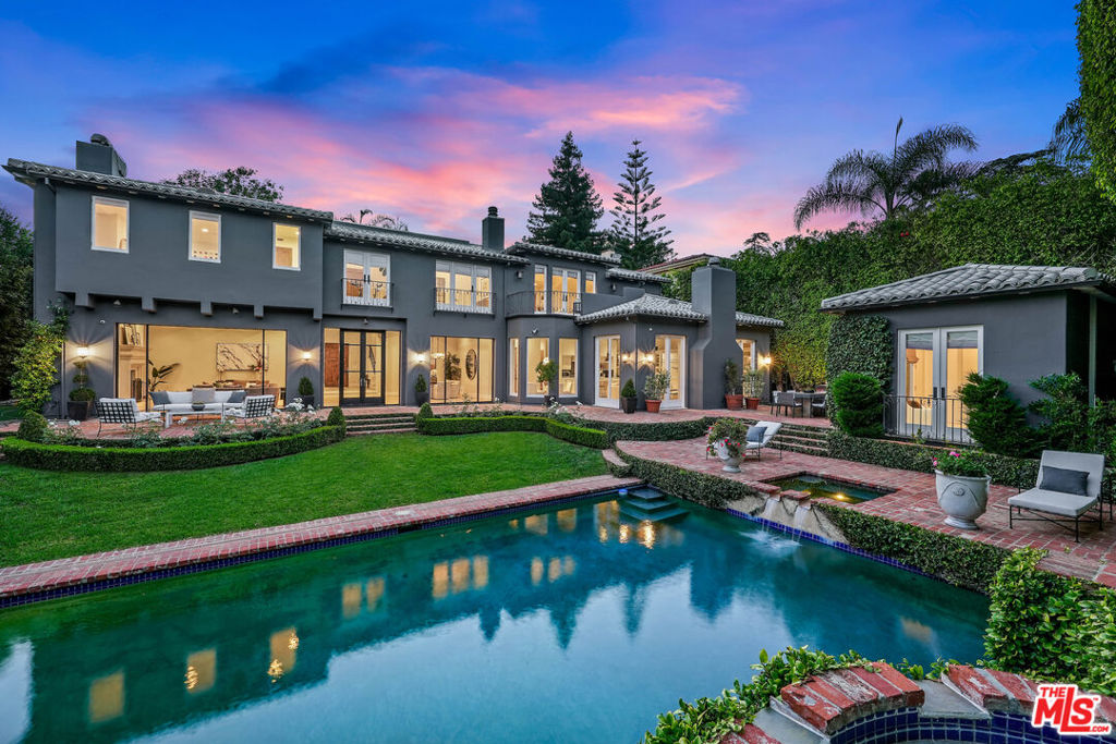 Set beyond gates in the coveted Riviera of Pacific Palisades, this Spanish-inspired abode pairs exquisite, authentic details with modern flair throughout its expansive 6,220-square-foot floor plan. Through the two-story foyer, an inrush of natural light creates a stunning canvas for quintessential California living, drawing one into the great room with exposed wood beam ceilings, the formal dining room, and the gourmet chef's kitchen. The kitchen is complete with top-tier appliances, a breakfast nook and an adjoining family room embraced by floor-to-ceiling glass doors. The home features six bedroom suites, including the luxe primary suite with expansive vaulted beamed ceilings, a private balcony and a dual-sided fireplace, along with a spa-like bath featuring two steam showers, a freestanding tub and dual closets. Mature privacy hedging envelops the unrivaled outdoor sanctuary, offering a built-in BBQ, pool, spa, and a versatile one-bedroom guest suite or pool house. A gated entrance, a 3-car garage and all-bedroom suites further enhance this architectural gem. Secluded within its own lush enclave yet moments from the best of Pacific Palisades, this Riviera architectural home presents a one-of-a-kind find on LA's Westside.
