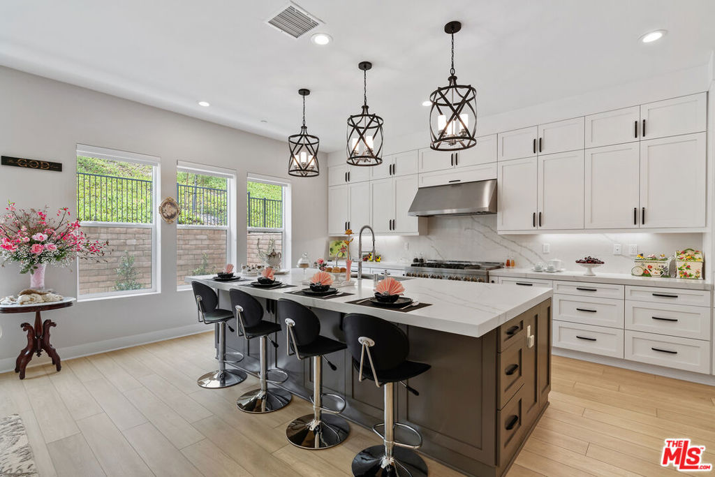 Located within Montebello's prestigious guard-gated Metro Heights community, this thoughtfully curated Toll Brothers residence redefines modern hillside living through an effortless blend of contemporary design, lifestyle flexibility, and resort-style amenities. Set across three levels, the Outlook Elite offers a balance of refined materials and inviting spaces, designed as much for daily comfort as for elevated entertaining. A soaring three-story foyer welcomes you into a home where every space has intention. Just beyond, the living room centers around a sleek modern fireplace, framed by natural light and warmth. French doors open directly to the outdoor living area, creating the perfect setting for al fresco dining, weekend lounging, or gathering under the stars. The kitchen, thoughtfully positioned at the heart of the home, features clean lines and high-end JennAir appliances. Quartz countertops, a walk-through pantry, and direct access to the formal dining room offer both functionality and sophistication. Every surface has been carefully selected, with finishes that reflect a quiet sense of luxury. With five bedrooms and seven bathrooms, the layout is designed for privacy, versatility, and ease. On the main floor, a guest suite doubles as an ideal office, tucked away for focus yet easily accessible. Upstairs, the primary suite serves as a peaceful retreat with a generous walk-in closet and a spa-inspired bathroom that includes a deep soaking tub, dual vanities, and a rain-style shower surrounded by porcelain tile. Two additional bedrooms feature en-suite baths, while a third shares a beautifully appointed hall bath. An open loft provides additional space for reading, working, or relaxing. On the third level, a flexible family room opens to a covered balcony with sweeping views, offering the perfect space for a home theater, game lounge, or creative studio. Every inch of the home is finished with thoughtful details including handcrafted tilework, premium quartz surfaces, and a cohesive, timeless material palette. Outside, the Metro Heights lifestyle unfolds. Residents enjoy access to a private clubhouse, resort-style pool and spa, state-of-the-art fitness center, and elegant social lounges. Scenic walking trails and lush landscaped paths weave throughout the community, offering panoramic city views and peaceful green spaces that make everyday living feel extraordinary. Additional features such as a whole-home water softener, a solar panel system, and full interior insulation reflect the home's commitment to efficiency and comfort. Rarely does a new construction home offer this level of intention, design, and community. This is more than a home. It's the beginning of your next chapter in Montebello's most desirable hilltop enclave.
