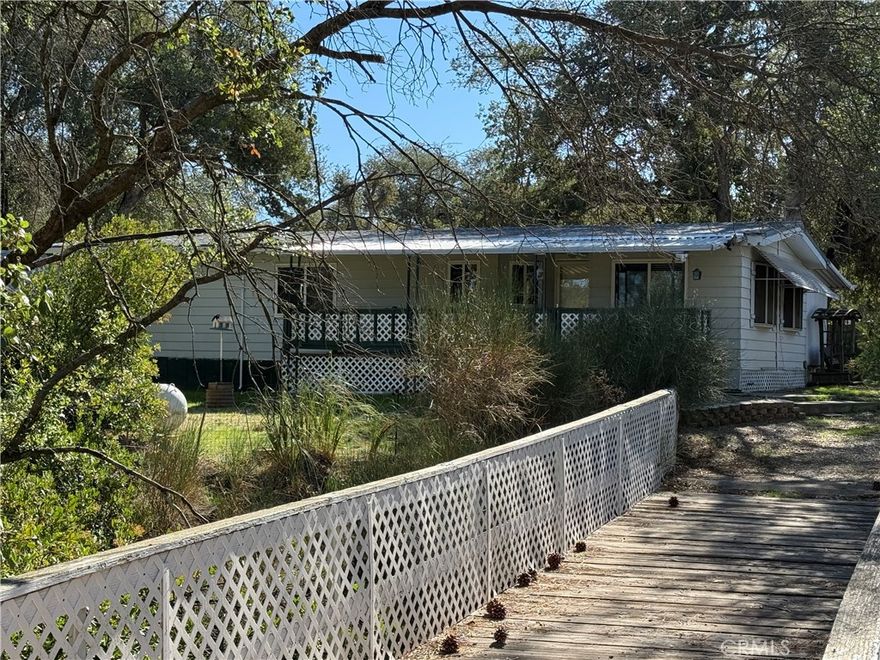 TURNKEY!! At the end of the drive in the cul-de-sac, this cutie is ready and waiting for a new owner! Cross the charming bridge to your oasis in the trees! This one checks all the boxes.  Two bedrooms plus a third office/bedroom/craft room with built in desk and laundry and even an adorable propane stove in the living room for those chilly winter evenings. Fresh paint and flooring makes this one virtually care free! But wait, there's more! A detached two car garage and two car carport, storage/art studio and landscaping including sprinklers and perimeter fencing leave nothing to do but garden or just sit on the porch and enjoy your morning coffee!