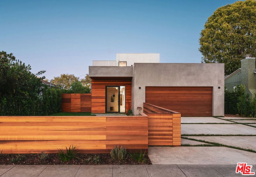 Located in the heart of Culver City on a quiet, tree-lined street, this organic modern architectural compound is newly built and ready for the most discerning buyer. Spanning 4 bedrooms and 4.5 bathrooms across approximately 3,600 square feet of living space, this home is a true turnkey residence. Upon entry, a welcoming foyer opens to a spacious living room filled with natural light and large glass sliding doors that extend the living space to a quiet, hedged side yard. A central courtyard gracefully separates the living room from the kitchen and dining area, while also serving as an ideal setting for indoor-outdoor entertaining. Sliding glass doors from both sides of the courtyard connect each living space seamlessly. The kitchen and dining areas are open-concept, offering additional space for casual seating and relaxing. The kitchen features a large waterfall quartz island, stainless steel Thermador appliances, floor-to-ceiling custom cabinetry, cabinet-paneled refrigerator and freezer, countertop seating, and direct access to the yard. A powder room is conveniently located on the main level, perfect for guests. This floor also includes a guest bedroom with an ensuite full bathroom. Upstairs are three bedrooms, three bathrooms, and a laundry room, along with access to a rooftop deck through the main hallway. The primary suite is a true retreat, sun-filled, serene, and surrounded by treetop views. The primary bathroom spares no expense, showcasing a dual floating vanity, a freestanding soaking tub, and an oversized frameless glass shower. A large walk-in closet with custom built-ins and LED lighting completes the suite. Two additional bedrooms, each with their own ensuite bathrooms, are finished with the same high-end materials found throughout the home including Toto toilets. The private, secure backyard is framed by hedges and features pavers for alfresco dining and the large flat grassy area is perfect for various outdoor activities. 4160 Keystone Avenue is ideally located just minutes from Carlson School and downtown Culver City's shops, restaurants, and boutiques, as well as major entertainment hubs including Fox Entertainment and Sony Pictures. Don't miss the opportunity to live in this well-designed architectural gem in one of Culver City's most coveted pockets.