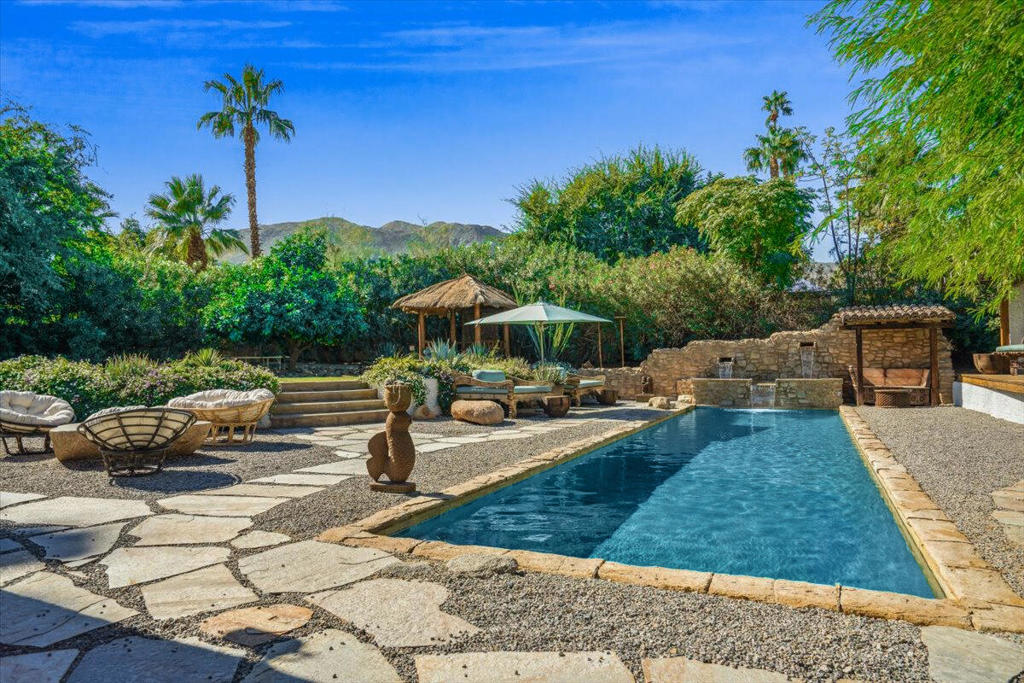 The Moroccan of Rancho Mirage is a true taste of Tangiers in the middle of the Californian desert. Originally built in 1950 this historical estate is a walled, gated oasis sitting on nearly an acre of land. Re-imaged by acclaimed designer Colas Moore it is both full of original charm and well considered luxurious detail. Behind solid mahogancy doors a serene fountain lined indoor courtyard welcomes you into the Hacienda style property. The house features a large master suite with private bath at one end and two further bedrooms and a bathroom at the other, with outside soaking tub and shower near guest bedrooms. A newly renovated modern kitchen finished with high end appliances and comfortable dining area flanks the spacious living room featuring vaulted wood beam ceilings,fireplace and quartzite flooring. The adjacent den opens up to a beautifully landscaped garden with citrus trees, magnificent lap pool and shaded napping cabanas. A large outdoor BBQ station and firepit lounge provide the perfect alfresco dining experience complete with panoramic mountain views. There's additonal 1114 SF not calculated in assessors information.