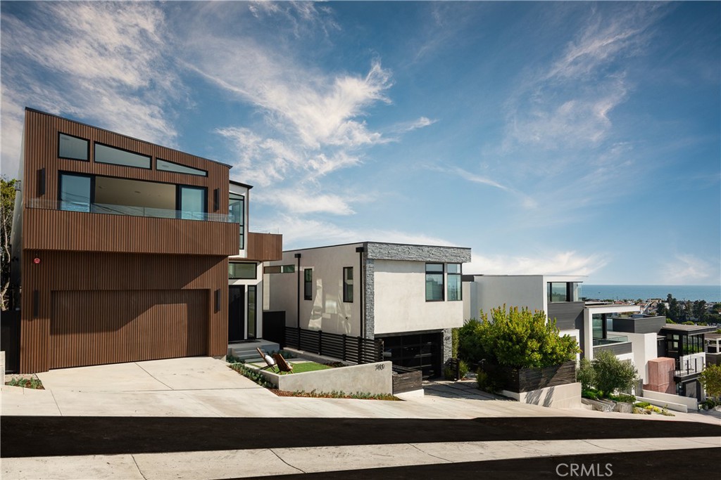 Welcome to 740 24th Place in Hermosa Beach – a brand-new architectural triumph that epitomizes sleek design and sophisticated luxury boasting panoramic ocean views of the entire Santa Monica Bay. Spanning 5,729 square feet, this 6-bed 5.5 bath modern masterpiece with seemingly endless glass walls that effortlessly merge indoor and outdoor living and offer vistas in all directions. An incredibly thoughtful floorplan showcases designer perfect touches at every turn including high-end Brizo fixtures, carefully selected lighting and European white oak wood flooring. Upon entry to the main level, you’ll find four well-appointed bedrooms, two with ocean views, and a shared family room that offers additional space for relaxation. The lower level is an entertainer’s dream providing one additional bedroom, an expansive recreation room complete with full kitchen & bar, and a separate living area that opens directly to the secluded backyard oasis. The top floor enjoys sweeping ocean views from the living room, front balcony and gourmet kitchen, which is equipped with top-of-the-line Thermador appliances, custom cabinetry, and elegant thin slab countertops. The primary suite is tucked on its own split-level behind the kitchen for added privacy featuring a formal foyer, luxurious spa-like bathroom with ocean view shower & tub, and large walk-in closet creating a peaceful retreat all its own. A stunning rooftop deck provides the perfect respite for unwinding while soaking in those renowned California sunsets. All three levels have ample storage, elevator access and a laundry chute for added convenience. Perched at the top of the hill in one of Hermosa’s most sought-after locations, 740 24th Pl is perfectly situated within walking distance to award-winning schools, restaurants, retail, the beach, parks and more. This is more than just a home – it’s a true sanctuary where you can enjoy unparalleled coastal living at its finest.