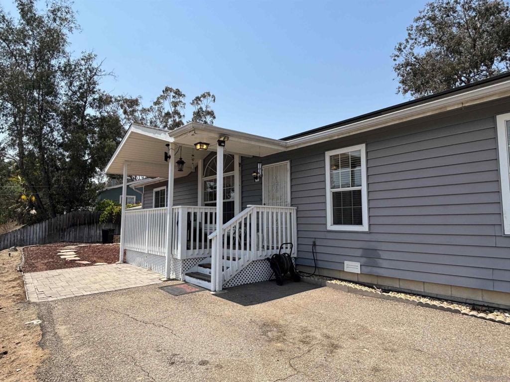 Perched above the street for added privacy, enjoy stunning views of El Capitan & distant East County mountains from both the charming covered front porch & the backyard. Inside, the heart of the home is the expansive kitchen featuring a breakfast nook, large eating bar, abundant counter space & custom cabinetry, all opening to the dining area & living room. The spacious primary suite includes a walk-in closet & an en suite bath with oversized soaking tub & separate shower. Owned solar keeps energy costs low year-round, & there’s even potential space for RV or trailer parking. Immaculately maintained, this home is a perfect blend of comfort, function & scenic beauty.