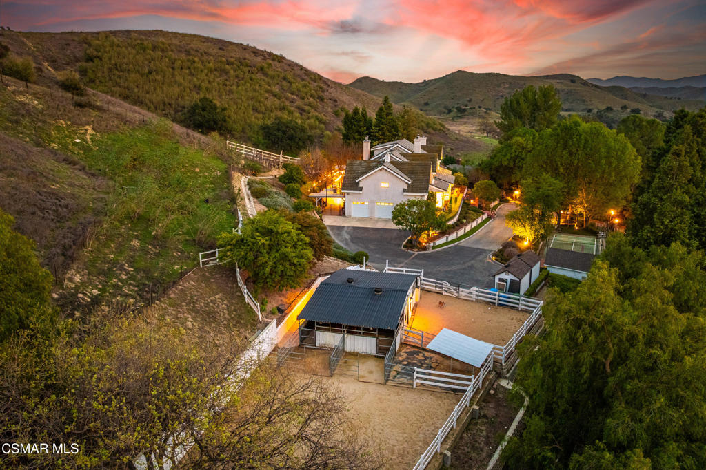 Discover a rare sanctuary in the heart of Old Agoura--where privacy, luxury, and nature converge on two sprawling acres. Tucked away at the end of a private road, this gated estate is embraced by mature trees and rolling hills, offering the ultimate escape from the everyday. Step inside to experience a home that seamlessly blends sophisticated design with modern farmhouse warmth. With a versatile floor plan featuring up to six bedrooms, including an expansive primary suite with a cozy fireplace and a private deck overlooking breathtaking vistas, this residence is designed for both comfort and flexibility. Entertain effortlessly in these attractive open-air spaces--host gatherings in the outdoor kitchen with grand island, unwind by the pool and spa, or enjoy quiet evenings under the stars by one of two fireplaces. Horse lovers will delight in the authentic barn, stalls, and turnouts, while the sport court and secret garden provide fun and relaxation for all ages. A stand-alone office, with its own yard, is perfect for remote work or creative pursuits. Proximity to scenic trails, top-rated schools, and local shopping creates a lifestyle that's both tranquil and connected. Welcome home to Old Agoura--where every day feels like a getaway.