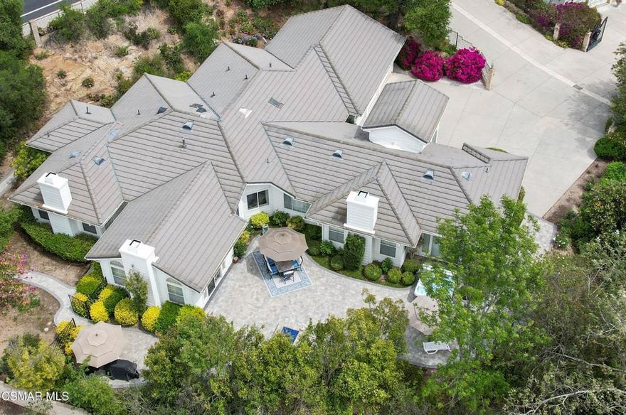 Conejo Oaks living without the Conejo Oaks price tag!  Private and secluded, tucked away from the street down a long driveway lies this beautiful Pleasant Oaks Estates home - a cherished single-story treasure on the market for the first time in almost 30 years.  Lovingly maintained and reflecting a true pride of ownership, this home offers a unique feeling of being in the islands with its tranquil soothing tones, birds of paradise, tropical trees and incredible sunset skies!  With its prime location backing Conejo Oaks and in the MATES Elementary School footprint, this home is a must have!  Upon entry, you're immediately captivated by soaring ceilings, wide hallways, distinctive architectural details, charming niches and a peaceful warmth that fills this home.  The gourmet kitchen boasts exquisite Italian granite, stainless steel appliances (which include a built-in refrigerator, double oven, range with a grill and a built-in microwave drawer), a walk-in pantry, a wet bar with a wine fridge, ample storage and a breakfast bar perfect for casual dining.  The kitchen opens to the family room with an inviting fireplace (one of 3!), ceiling fans and an abundance of natural light and is next to the formal dining room featuring a tray ceiling adding to the home's casual elegance.  As you retreat to your expansive primary suite through the grand double-door entry, you're greeted by a romantic fireplace, views of the gorgeous evening sky, a spacious oversized walk-in closet and a large bathroom with dual sinks, a jetted soaking tub and a stand-alone shower.  This wing also includes two secondary bedrooms, a full shared bathroom with dual sinks, a powder room, an indoor laundry room with storage and a utility sink and direct access to the attached three car garage.  On the opposite side of the residence, you'll find the formal living room offering a cozy fireplace, and a fourth bedroom and three-quarter bathroom, perfect for multi-generational living!  The large wrap-around lush yard features a firepit and hot tub, the perfect scene for enjoying stunning sunsets, gathering with friends and family or unwinding at the end of the day.  A private patio off of the primary suite also awaits, an ideal location for your morning cup of coffee, meditation or serene escape to begin your day.  Additional highlights of this wonderful home include Plantation shutters throughout, generously sized rooms and ceiling fans in all bedrooms.  Nearby award-winning schools, parks, trails, teen and adult centers, the library, shopping, dining and entertainment makes this lovely home a true gem!