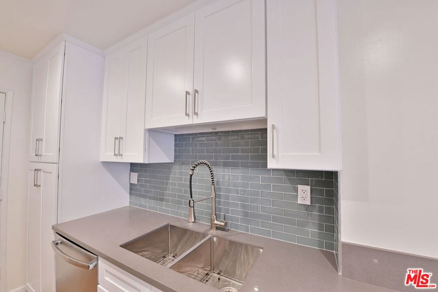 This modern 1 bedroom apartment features an open concept living area with wood style flooring, recessed lighting, and a beautifully updated kitchen with quartz countertops, sleek cabinetry, and a stylish glass tile backsplash. Large sliding doors lead to an oversized private patio, perfect for entertaining or relaxing outdoors. Freshly renovated and filled with natural light, this home offers a comfortable layout with contemporary finishes in a prime location.