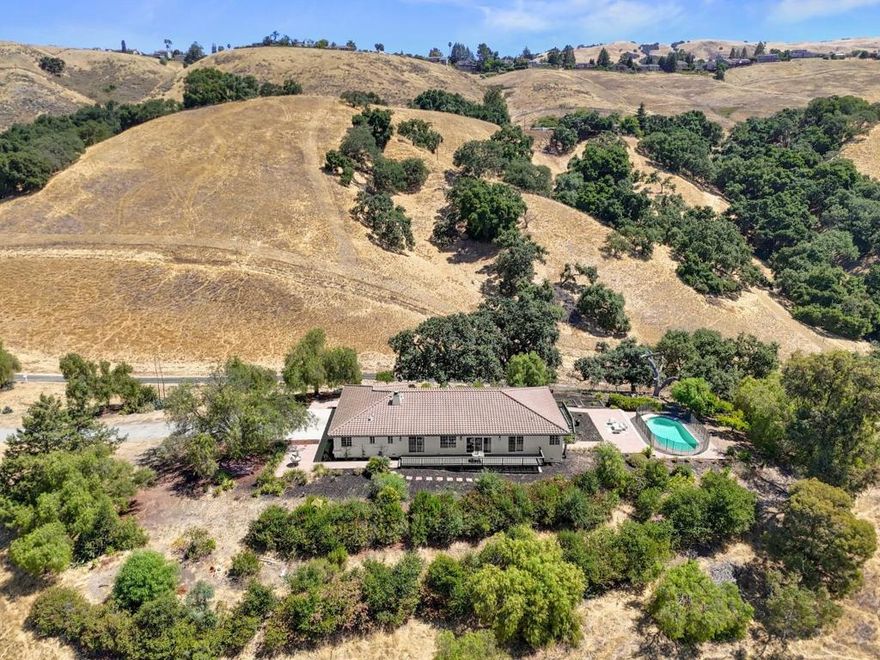 Welcome to 17101 Kruse Ranch Lane, truly once in a lifetime opportunity to create a subdivision of homes, dream horse property, and your own private estate. This stunning home features 4 bedrooms, 2.5 baths, and spacious 3-car garage, all set against breathtaking valley views on nearly 40 acres of land. The formal living and dining rooms boast vaulted ceilings and picturesque valley views. The kitchen is a chefs delight, equipped with GE stainless steel double ovens, a 4-burner electric cooktop, oak cabinets, and a cozy breakfast nook. Family room features vaulted ceilings, wet bar, fireplace, and patio access with more valley views. The luxurious primary suite includes sliding doors to the patio, walk-in closet, and bathroom with double sinks, a 3-person jacuzzi, and walk-in shower. Three auxiliary bedrooms are spacious and bright, each with carpet and double pane windows. Additional amenities include laundry room with hardwood floors and utility sink. The hall bathroom features tile floors, an oak vanity, and a shower over the tub. Enjoy the courtyard with a fountain, a swimming pool, and vegetable beds, all set against nearly 40 acres of open space. Located near Morgan Hills best amenities, including the Outdoor Sports Center, library, downtown, and easy access to Highway 101